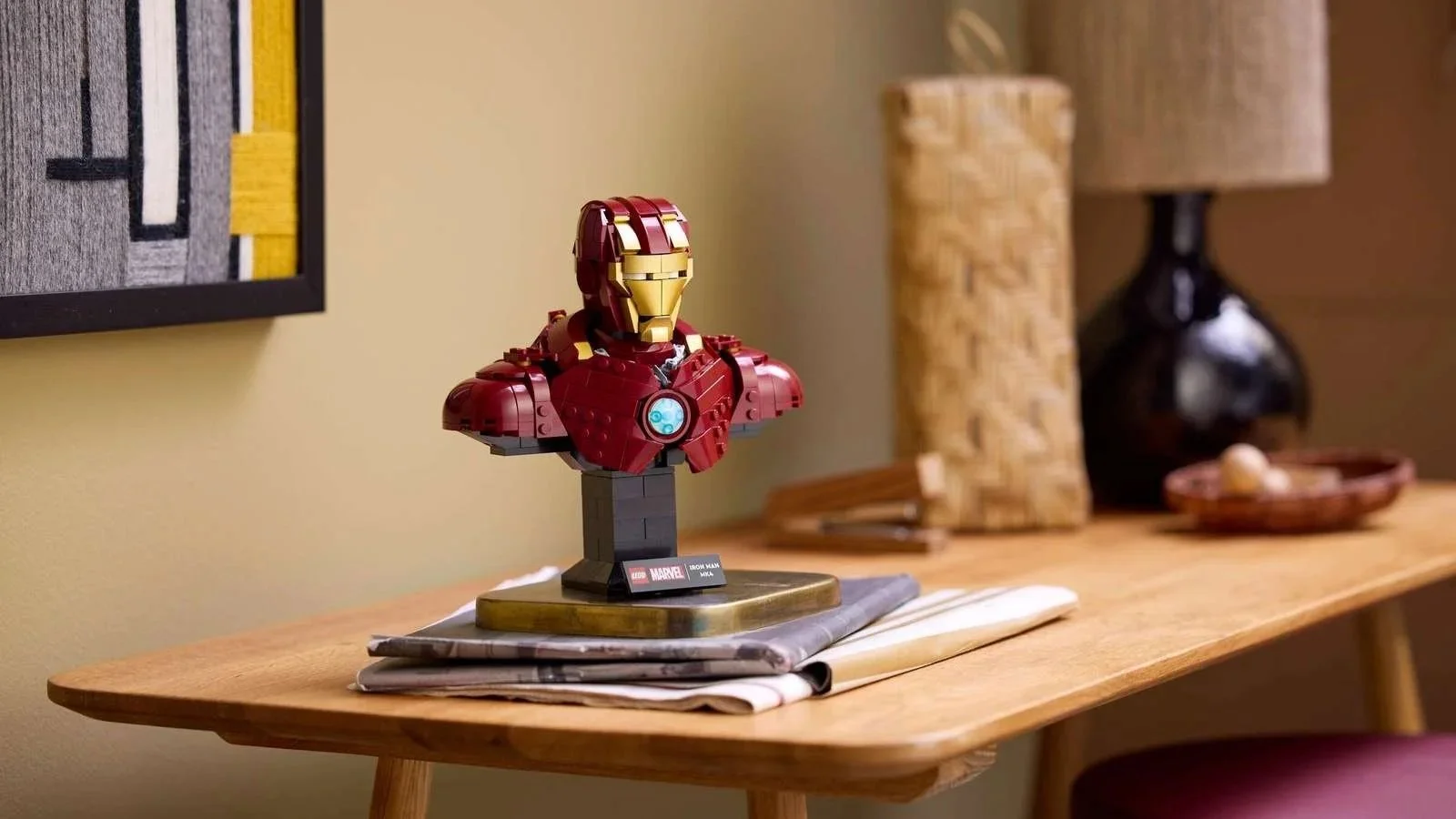 LEGO Marvel Iron Man MK4 Bust displayed on a stack of newspapers on a light wood console table in a living room