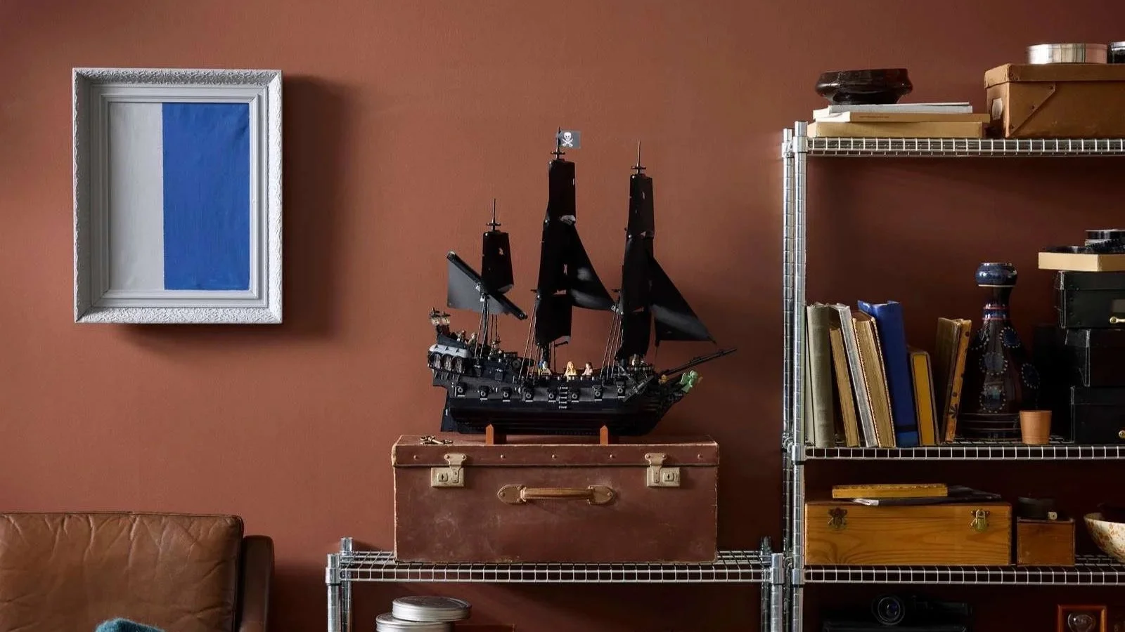LEGO Captain Jack Sparrow's Pirate Ship set displayed on a vintage trunk on open metal shelving