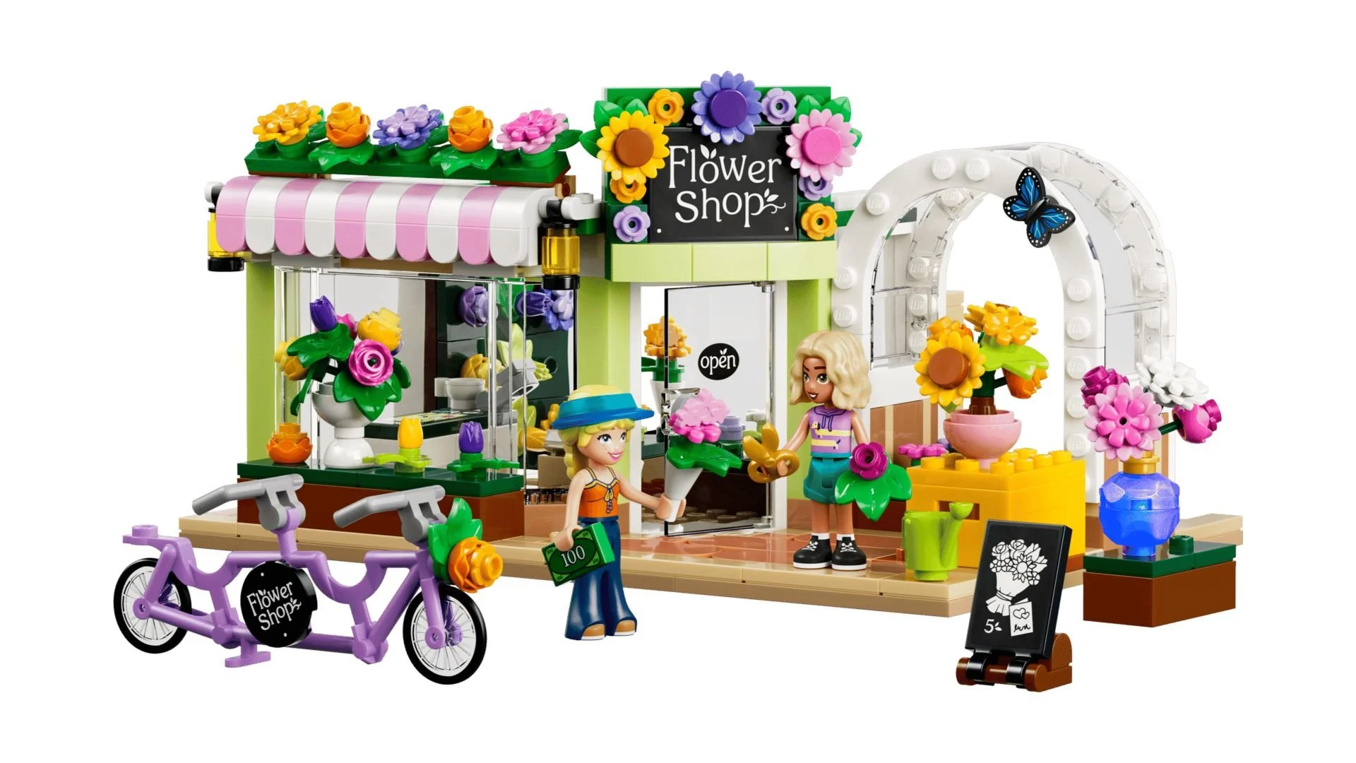 LEGO Creative Flower Shop set with a striped pink awning, flower-covered sign, white garden arch, purple tandem bike, and two figures at the shop door