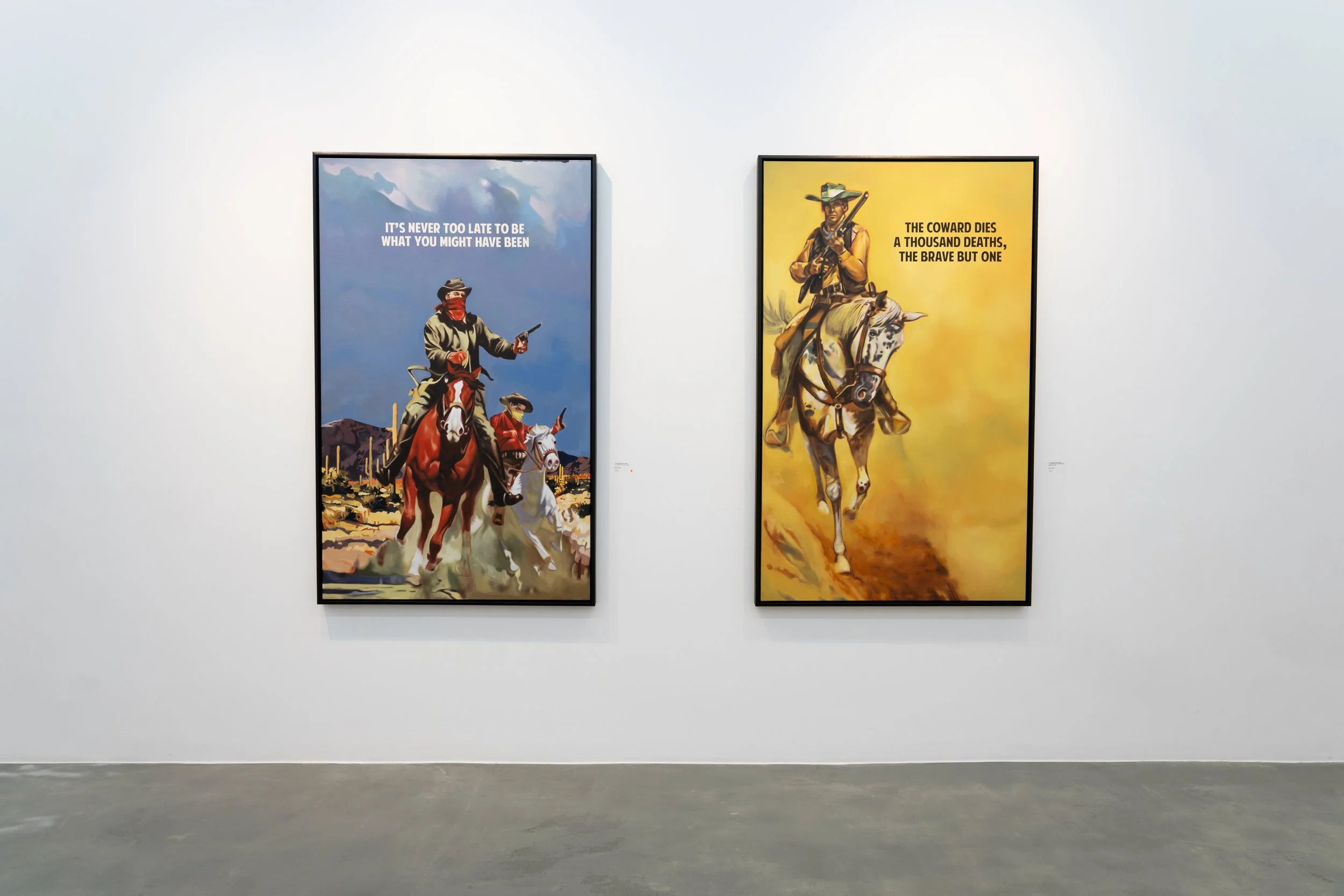 Two portrait paintings on a gallery wall. The left painting shows a cowboy with a red bandana over his face, riding a horse in a desert landscape. The right painting depicts a cowboy on a horse, wearing a hat and holding a rifle, with a quote about c