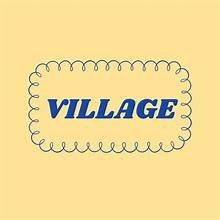 A sign with the word 'VILLAGE' in bold blue letters on a beige background with a decorative border
