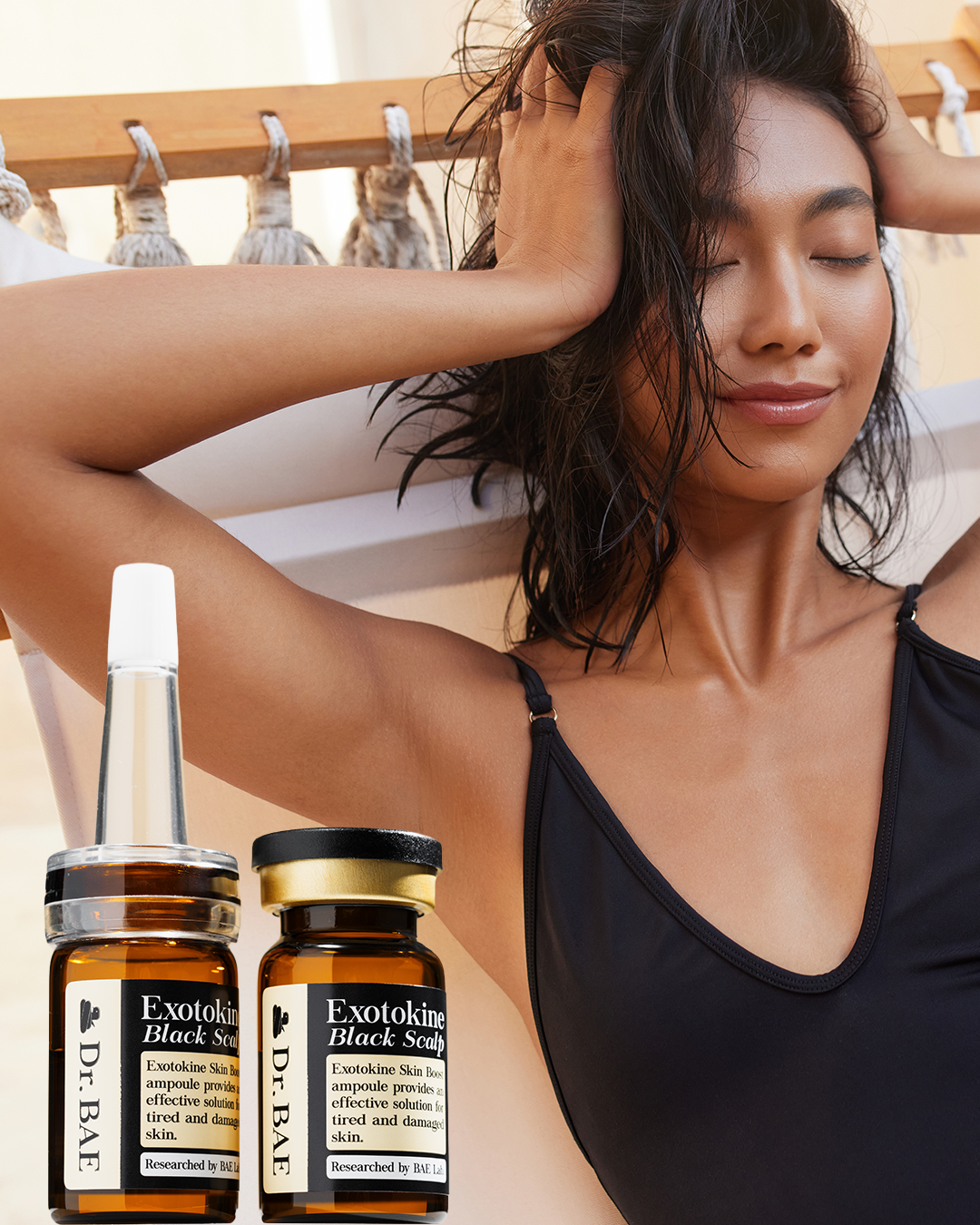 A woman with wet curly hair, relaxing outdoors with eyes closed, wearing a black tank top, with two bottles of Dr. BAE Exotokine Black Scalp Ampoule in the foreground.