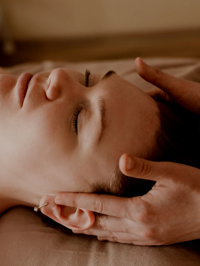 Person receiving a facial massage from a therapist.
