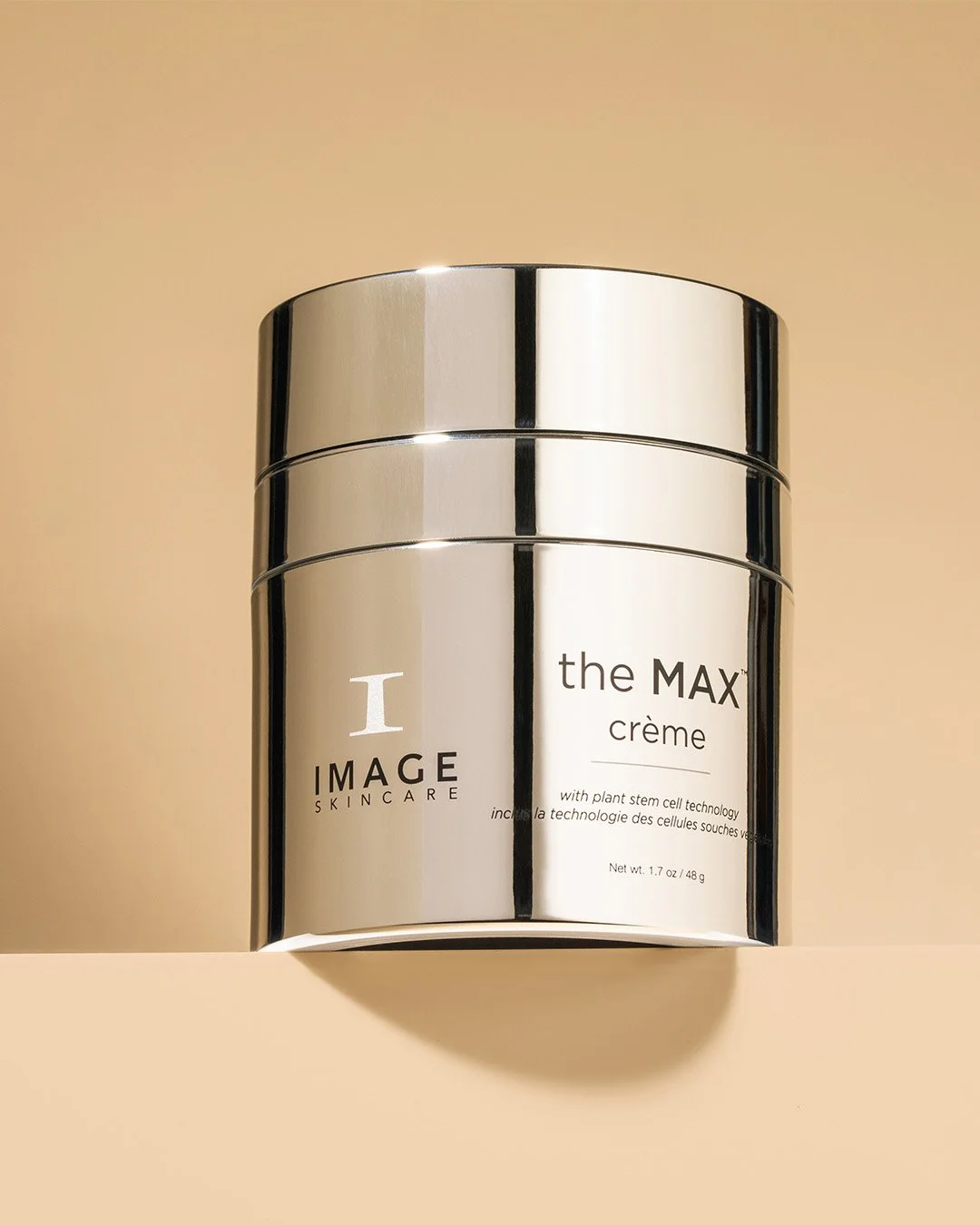 A silver jar of skincare cream labeled 'the MAX crème' by IMAGE SKINCARE, with plant stem cell technology, resting on a beige surface.
