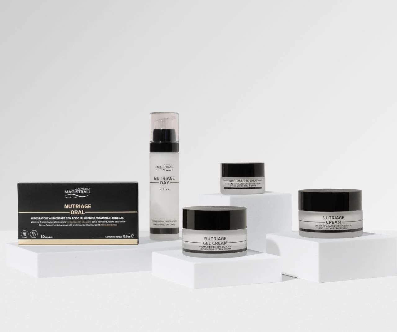 Collection of skincare products including Nutriage oral capsules, Nutriage day serum, and Nutriage eye and face creams, displayed on white platforms against a white background.