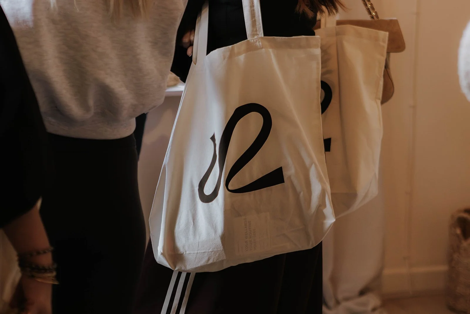 Person holding a Rise branded tote bag