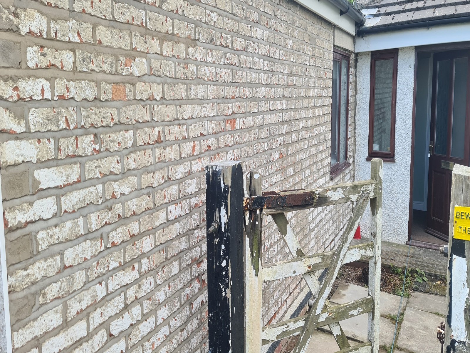 After grinding out the old morter and cleaning the joints of this cottage wall, a new lime render is pushed in to the joints and flattened off to make the wall water tight