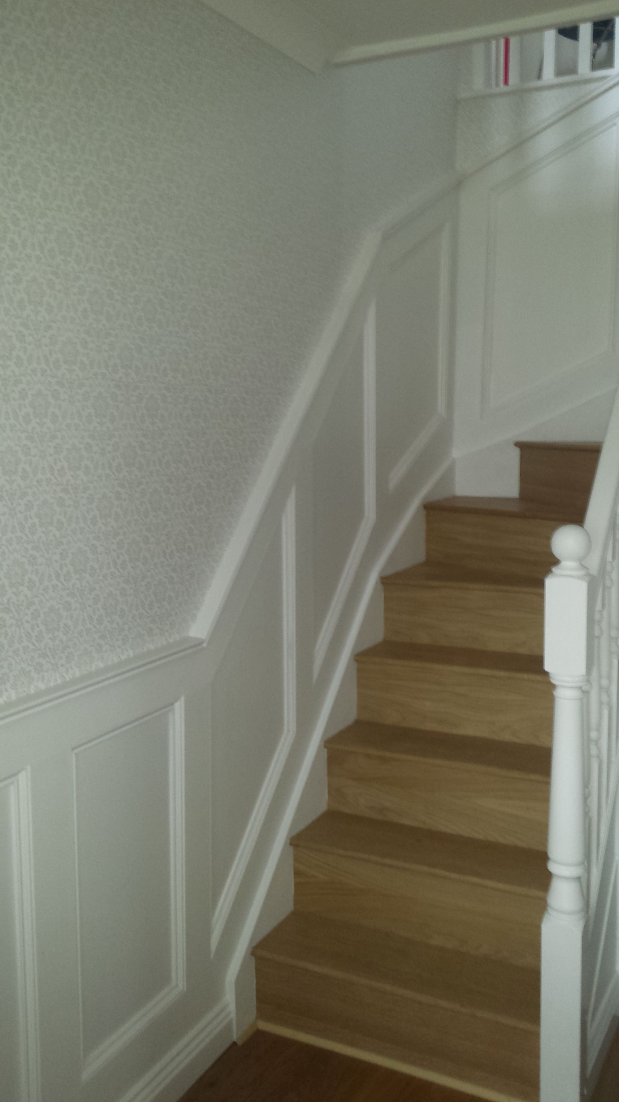 Completed bespoke staircase renovation with oak stair treads, white wall panelling and decorative mouldings in a Bridlington home by Abbeydale Builders.