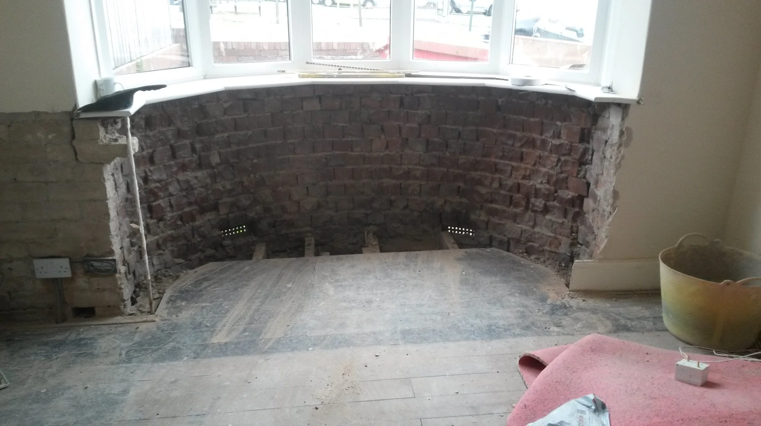The bay window of a bungalow in Bridlington with the original plaster removed back to exposed brick to allow for damp proofing of the bay window