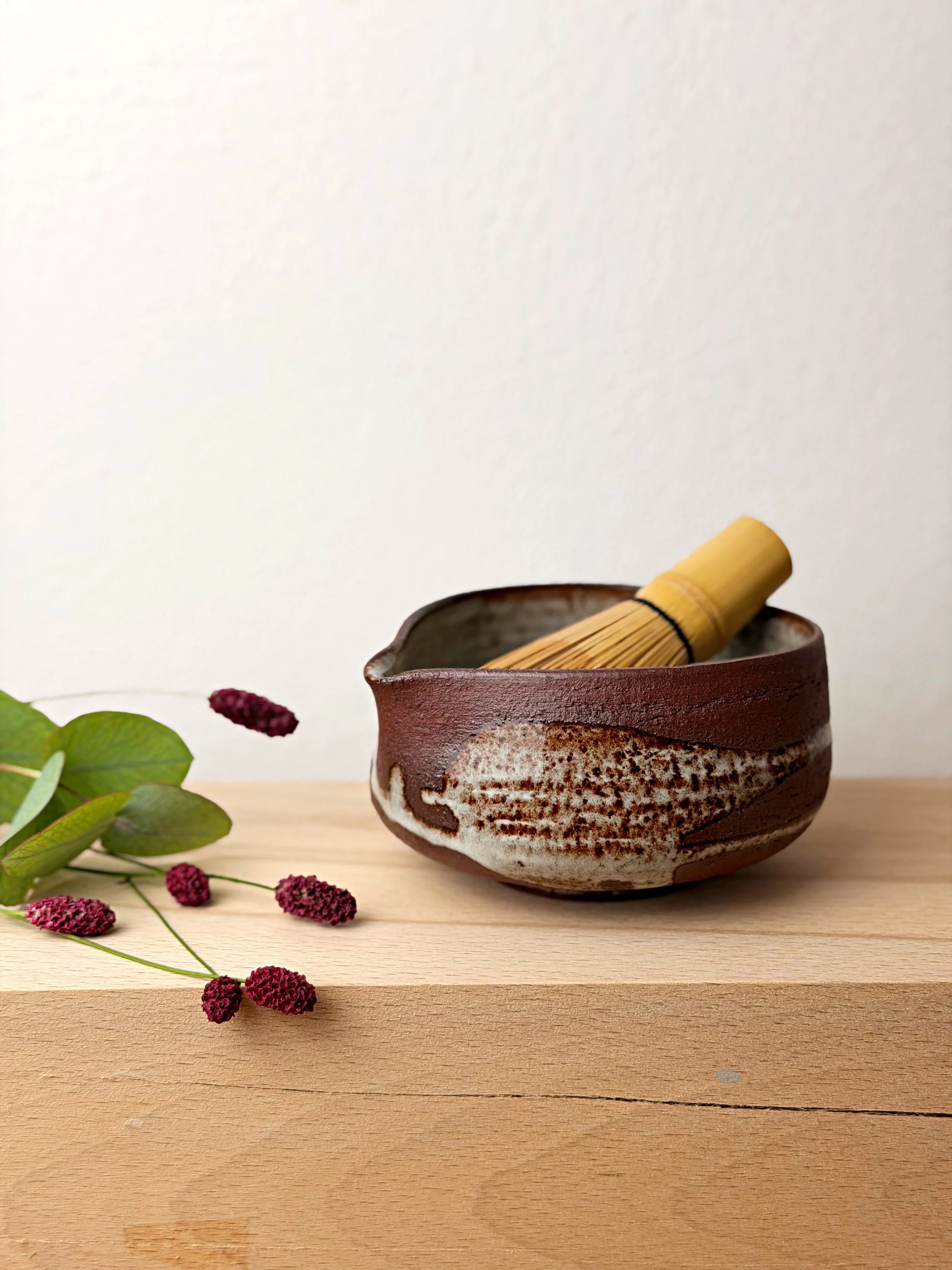 Handmade Earth & Light spouted matcha bowl in brown stoneware.