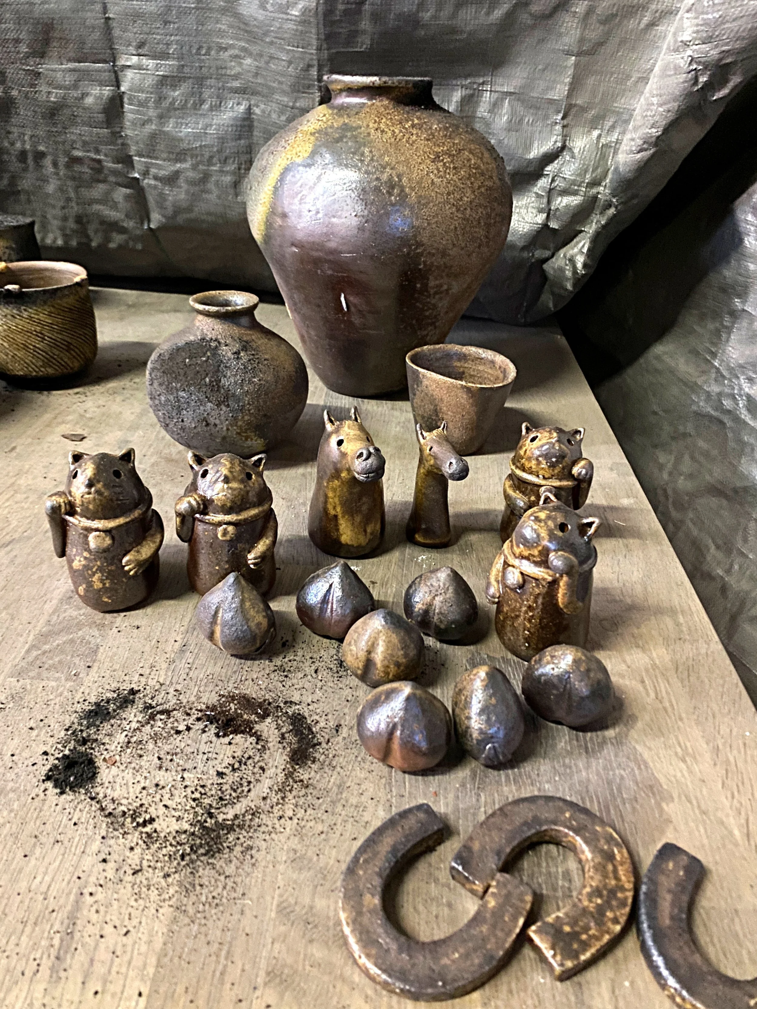 Pieces after unloading from the kiln, including my works in the background and small charms by Fumiyo Inai.