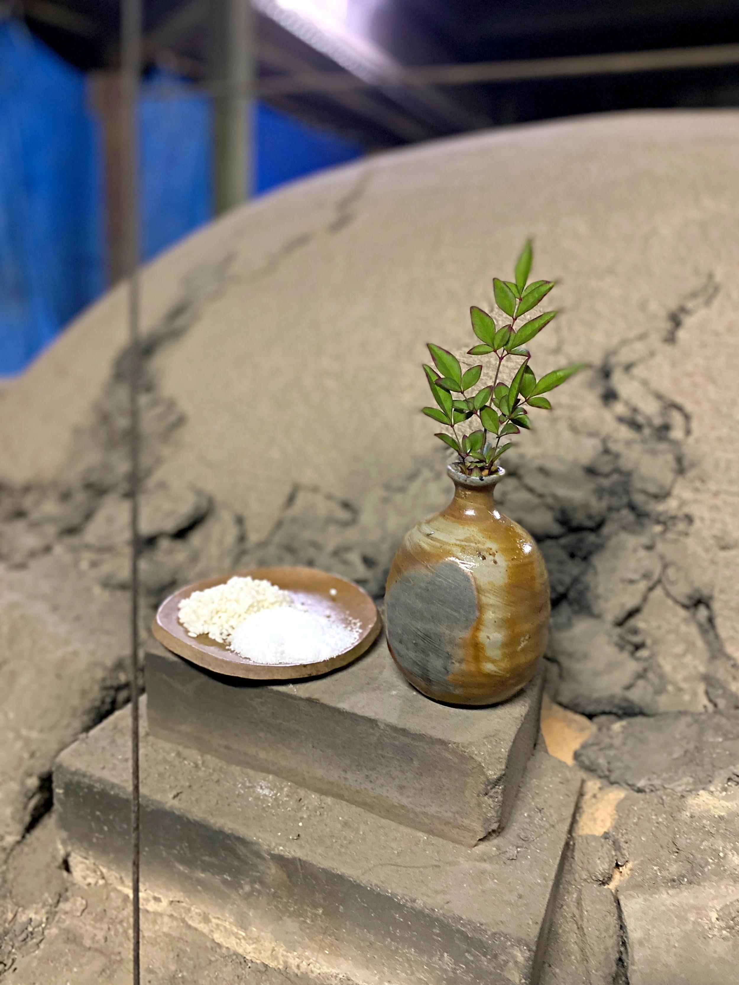 Offerings to the kiln gods placed above the main opening of the first chamber: a sake bottle, salt, and rice.