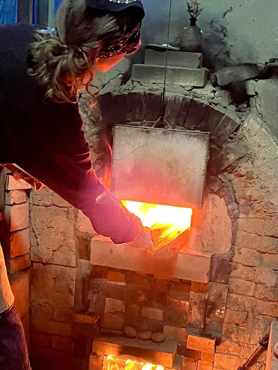 Feeding firewood into the first chamber of the noborigama kiln.