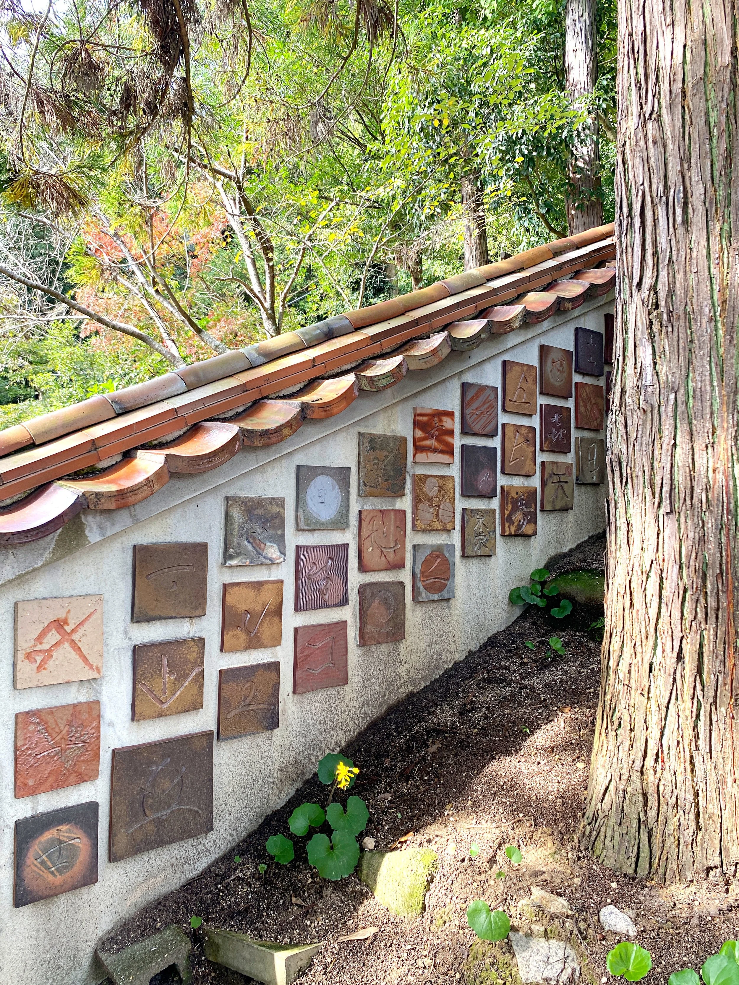 A wall beside the steps leading up to Amatsu Shrine in Inbe, decorated with tiles made of Bizen clay.