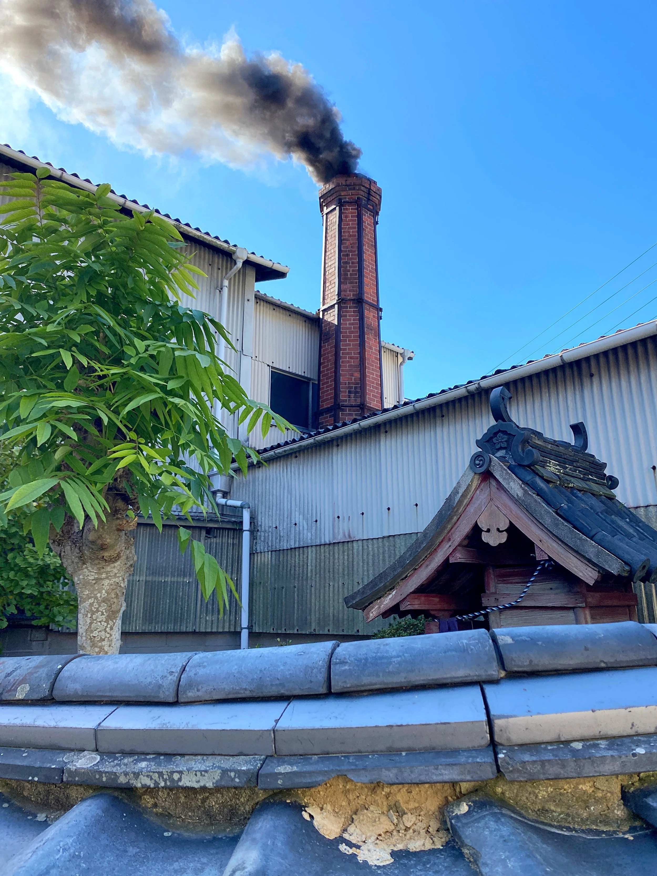 Smoking chimney of the noborigama kiln seen from the street.
