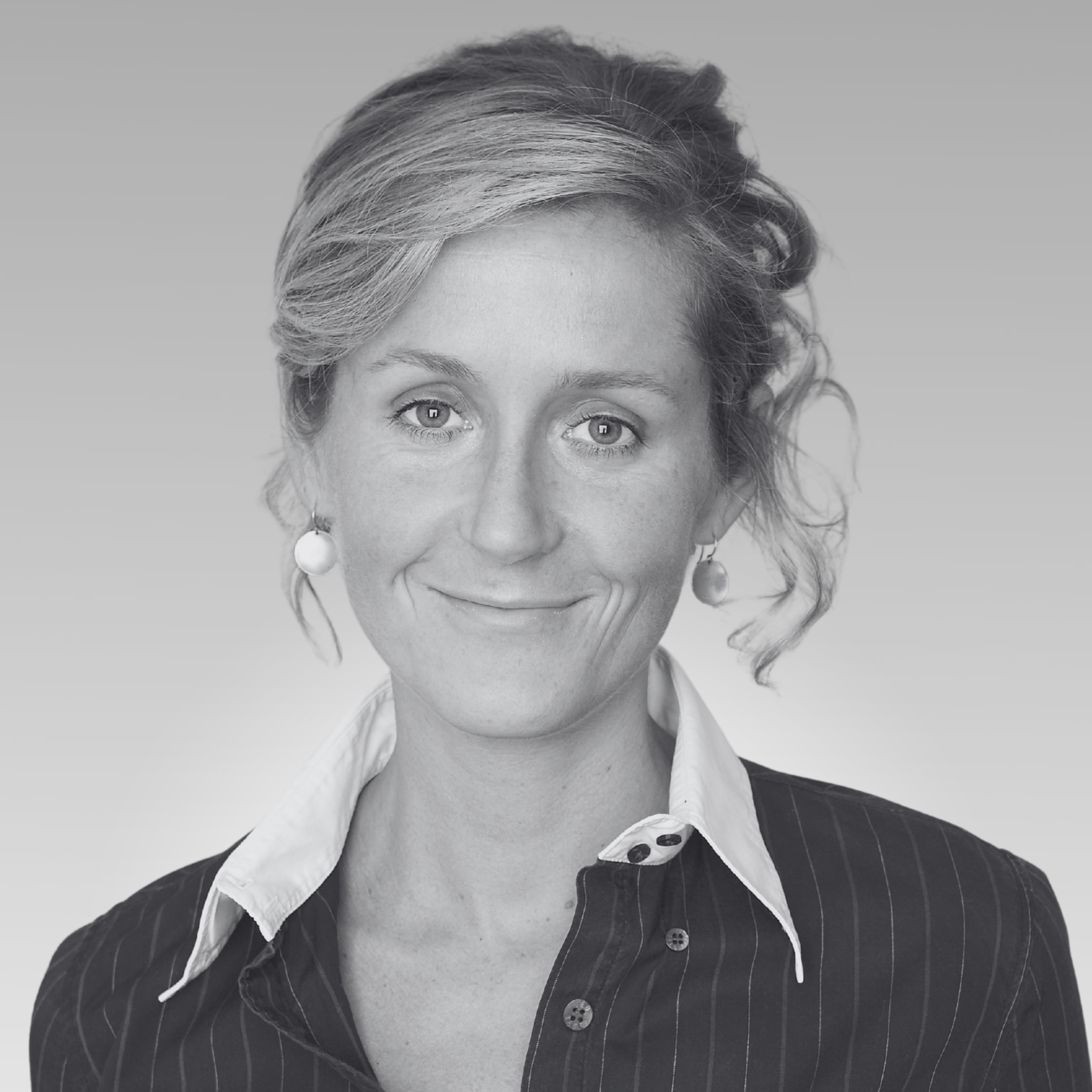 Black and white portrait of a woman with short wavy hair, large earrings, wearing a collared shirt and a pinstripe blazer.
