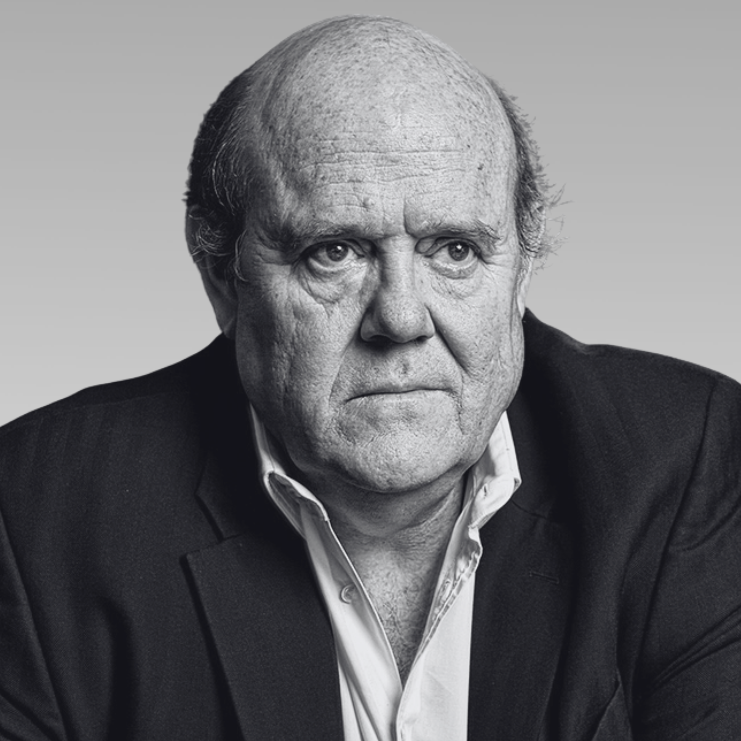 Black and white portrait of an elderly man wearing a suit and white shirt, looking directly at the camera.