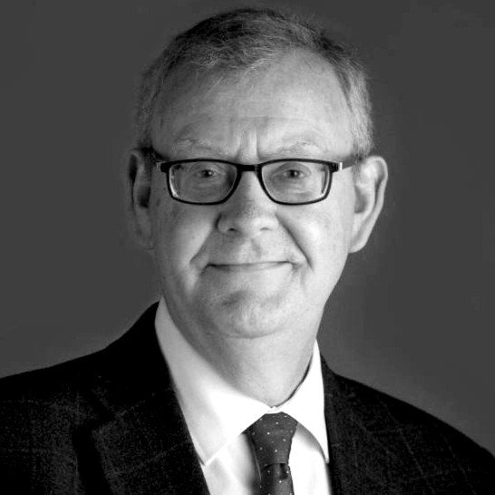 Black and white portrait of a man wearing glasses, a suit, and a tie.