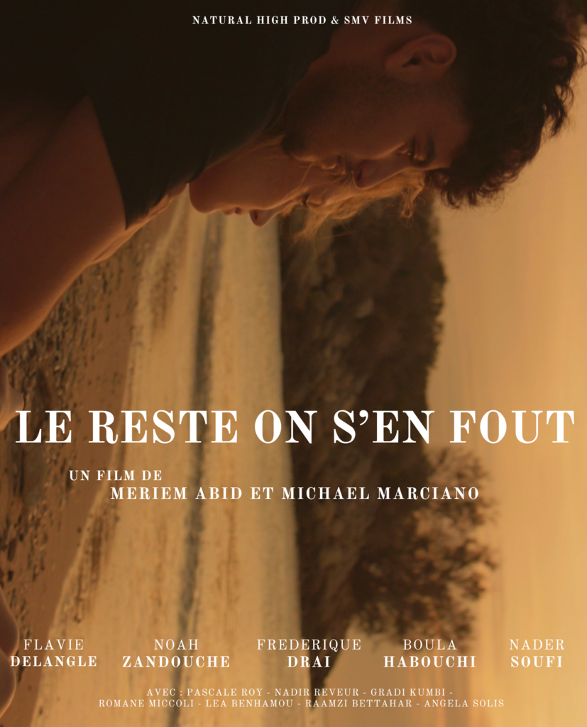 Une femme regarde pensivement vers le sol sur une plage au coucher du soleil.