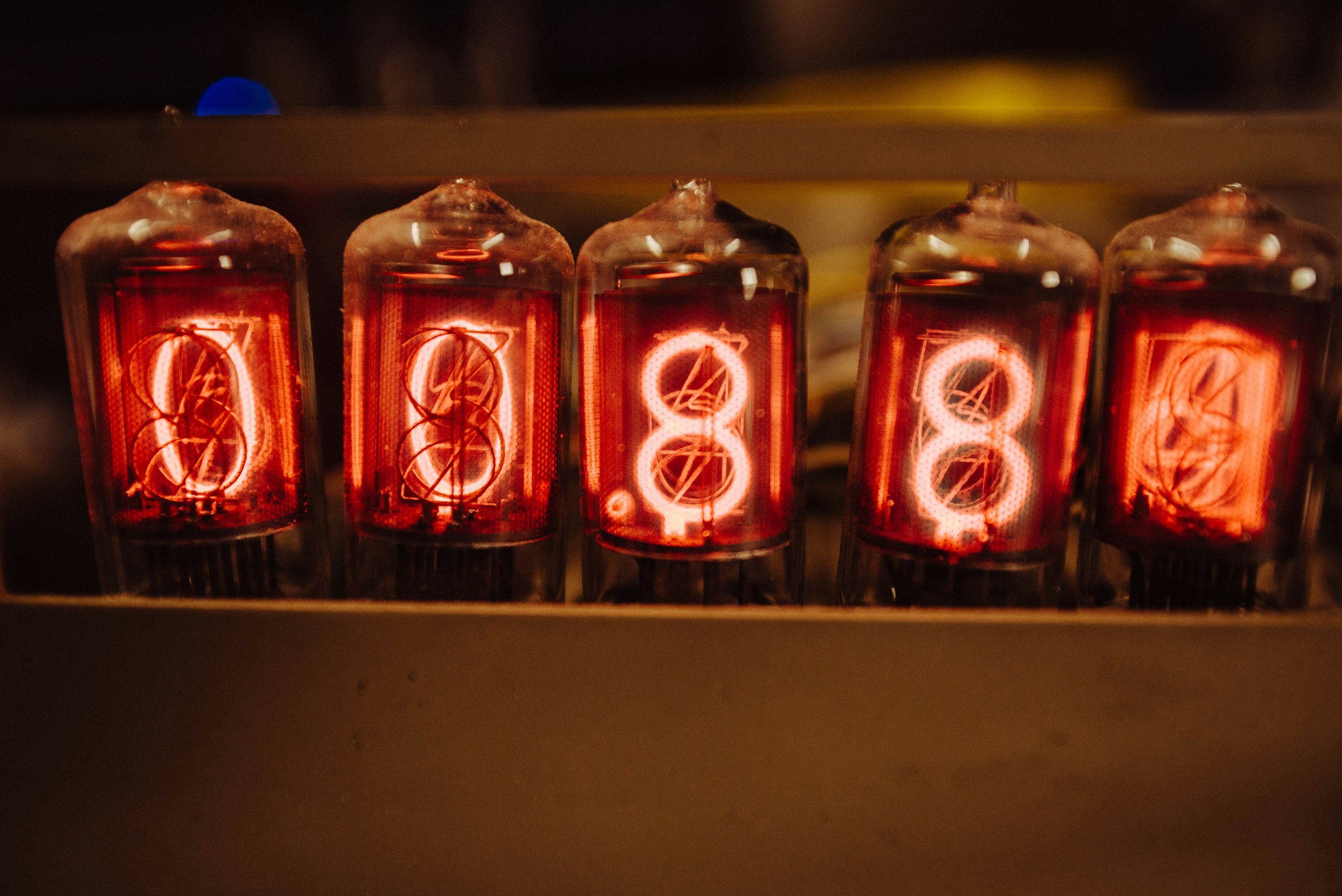 Close-up of five vintage vacuum tubes glowing orange inside a device.