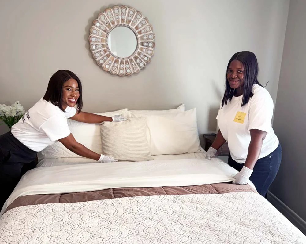 Two black women making a bed