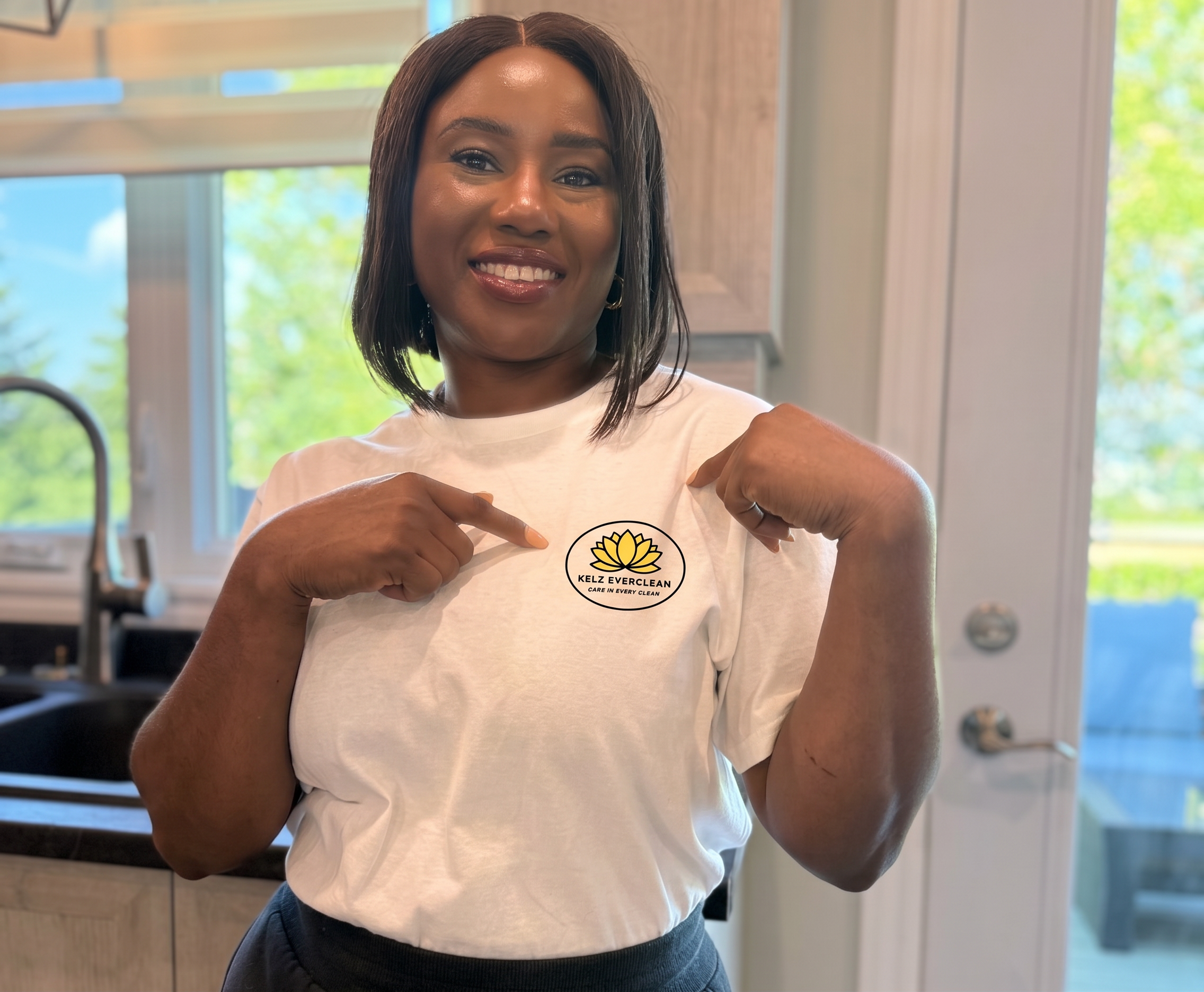 Adekelu Ogunleye pointing at her white t-shirt with the Kelz Everclean logo on it