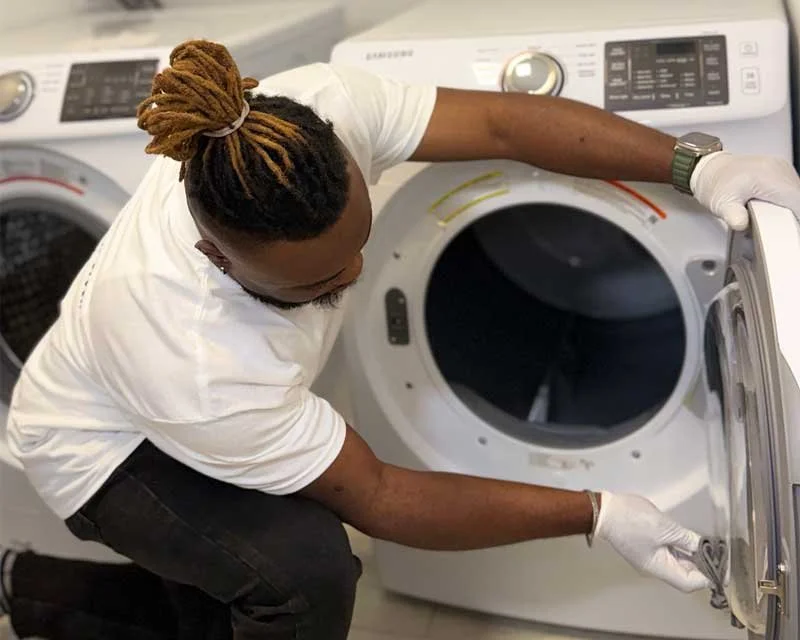 Man wiping down inside of washing machine