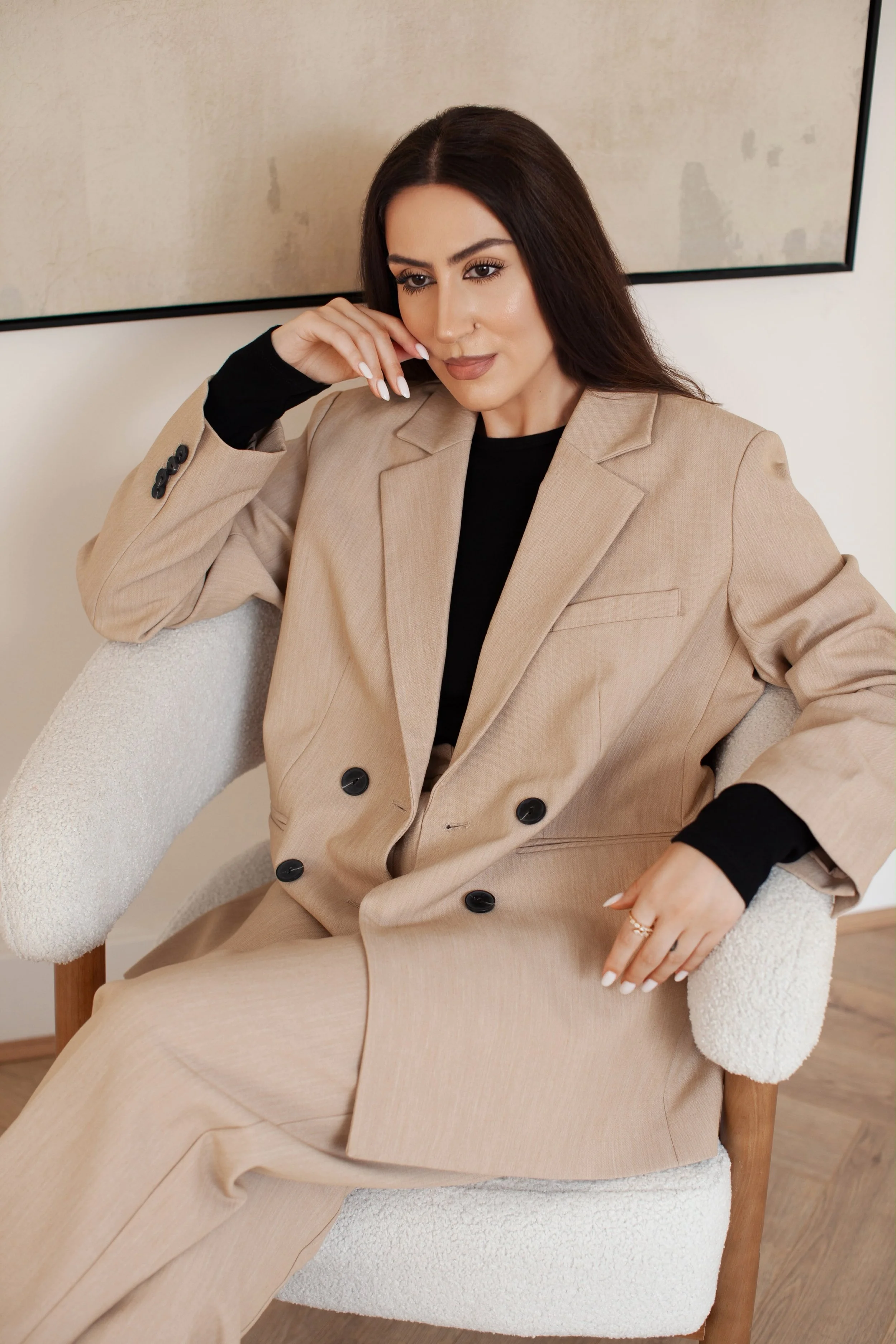 Oana Barabasa, founder of Feminine Signature, seated in a neutral tailored suit.