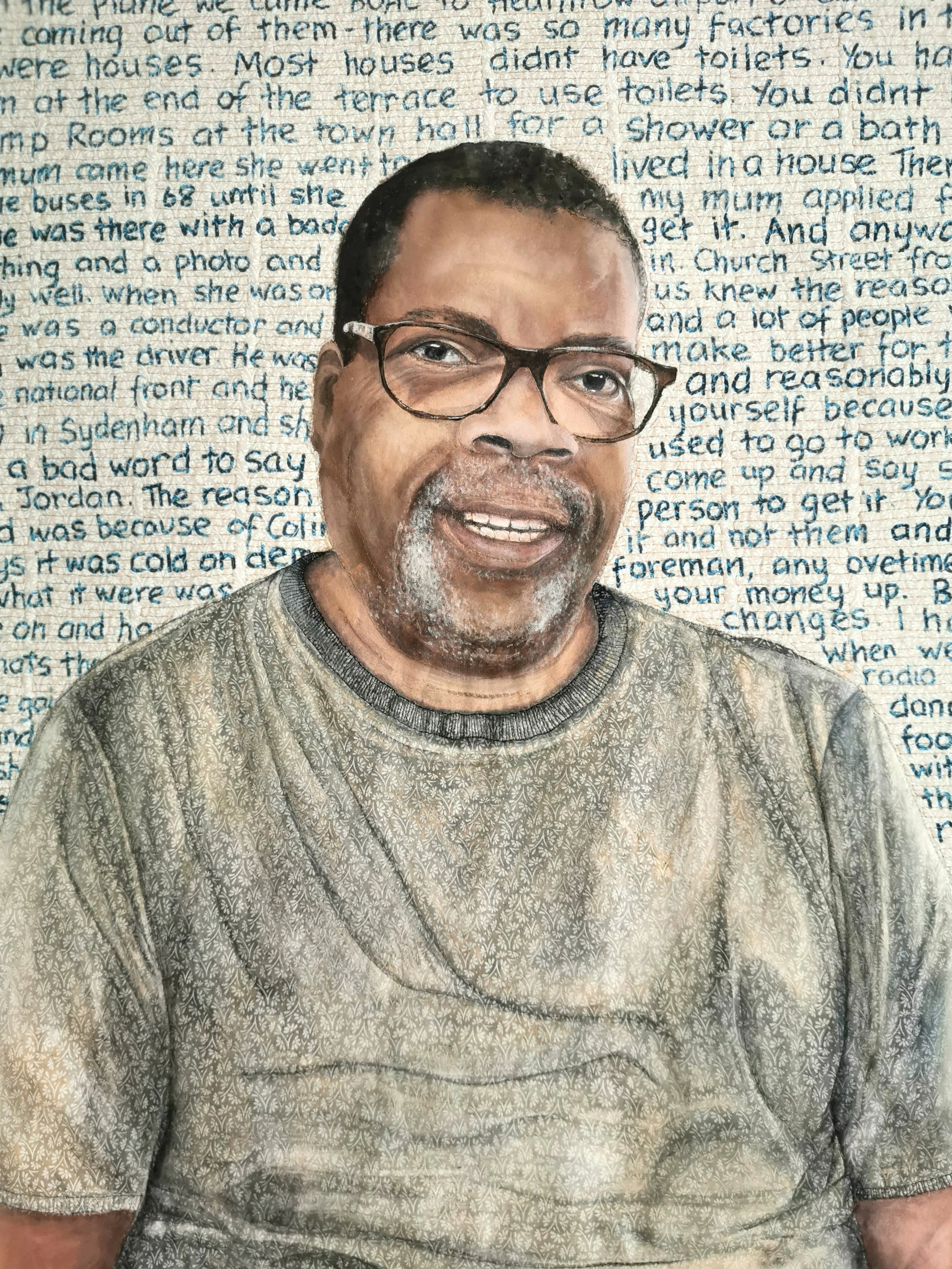 Portrait of a man wearing glasses with handwritten text in the background.
