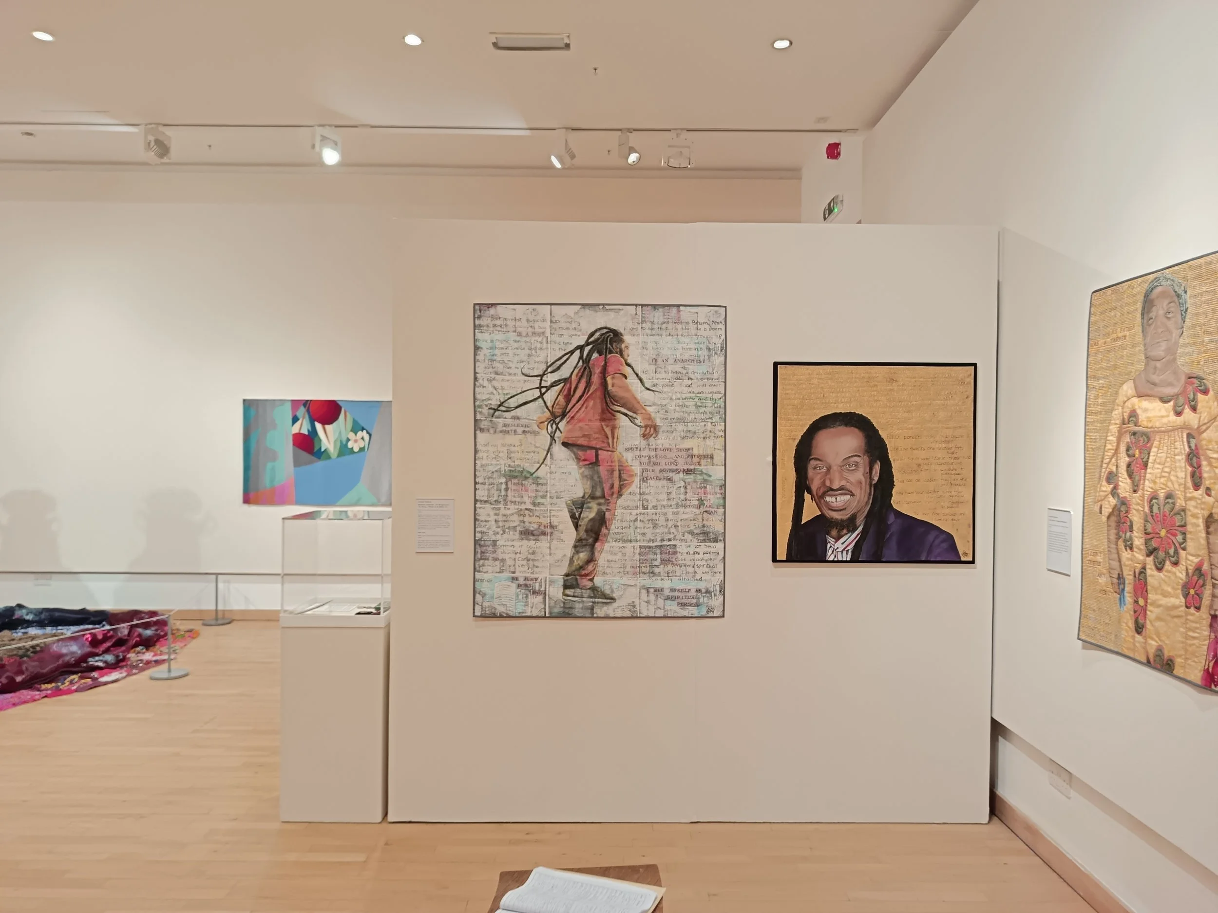 Annabel Rainbow's Unravelling History exhibition. Windrush Portraits and illustrations displayed on white gallery walls.