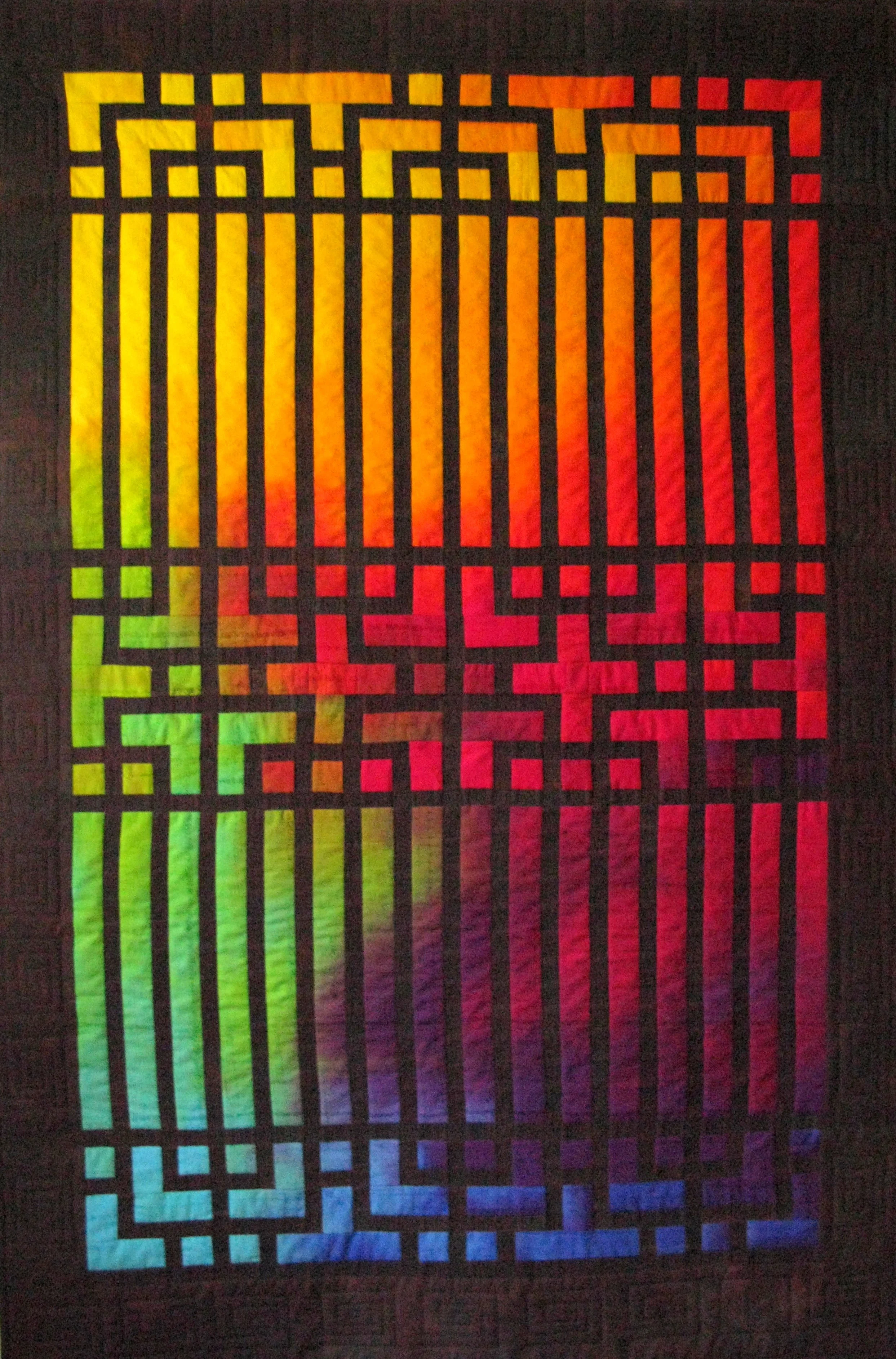 Colorful gradient quilt with black geometric overlay on a black border.