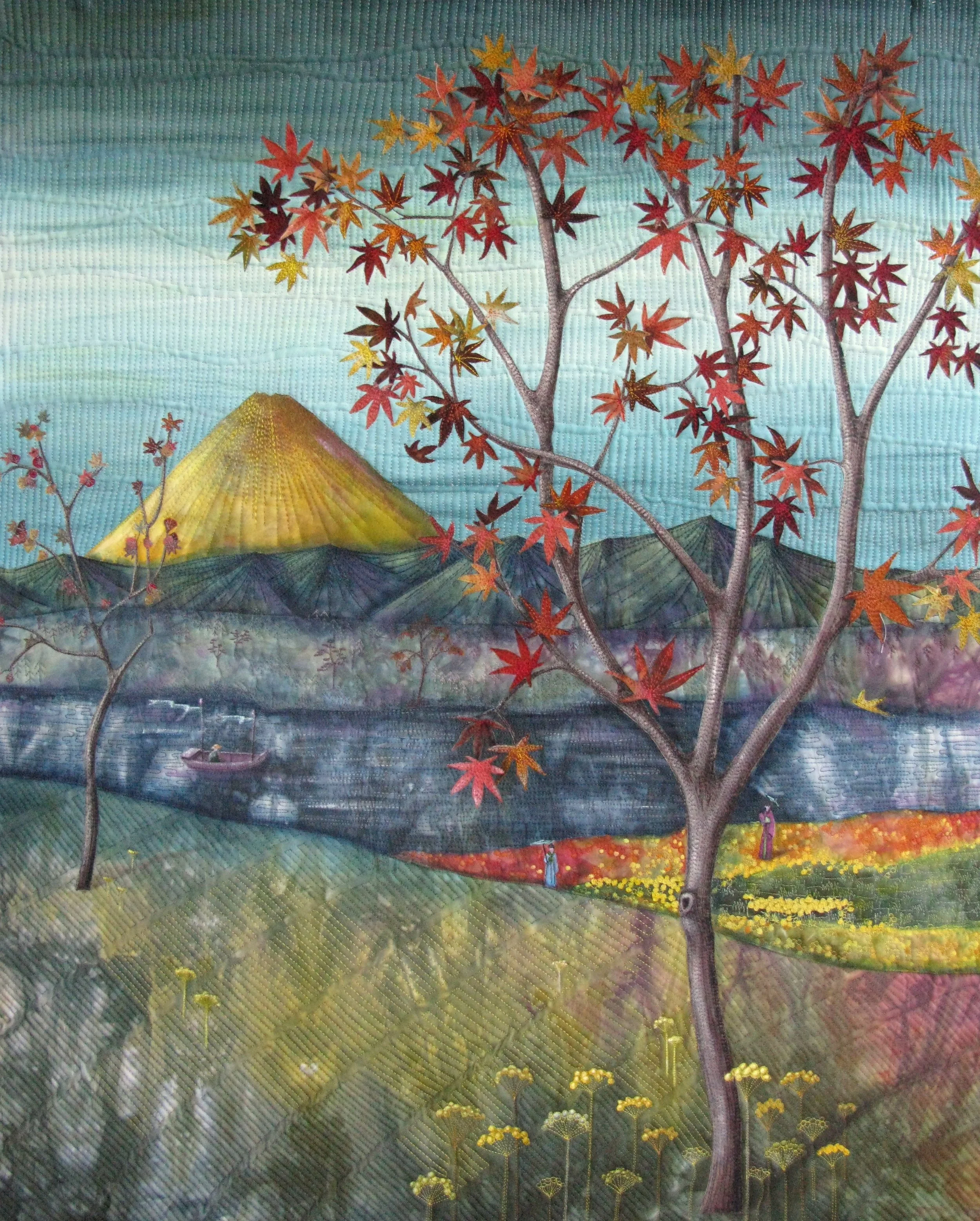 A quilted landscape depicting a mountainous scenery with a large yellow mountain in the background, colorful trees with red and orange leaves in the foreground, and a river flowing through the scene.