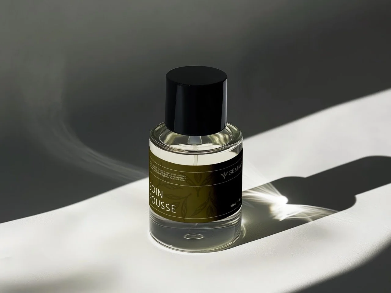 Flacon de produit de soins avec une étiquette verte et noire, placée sur une surface blanche, créant une ombre distinctive.