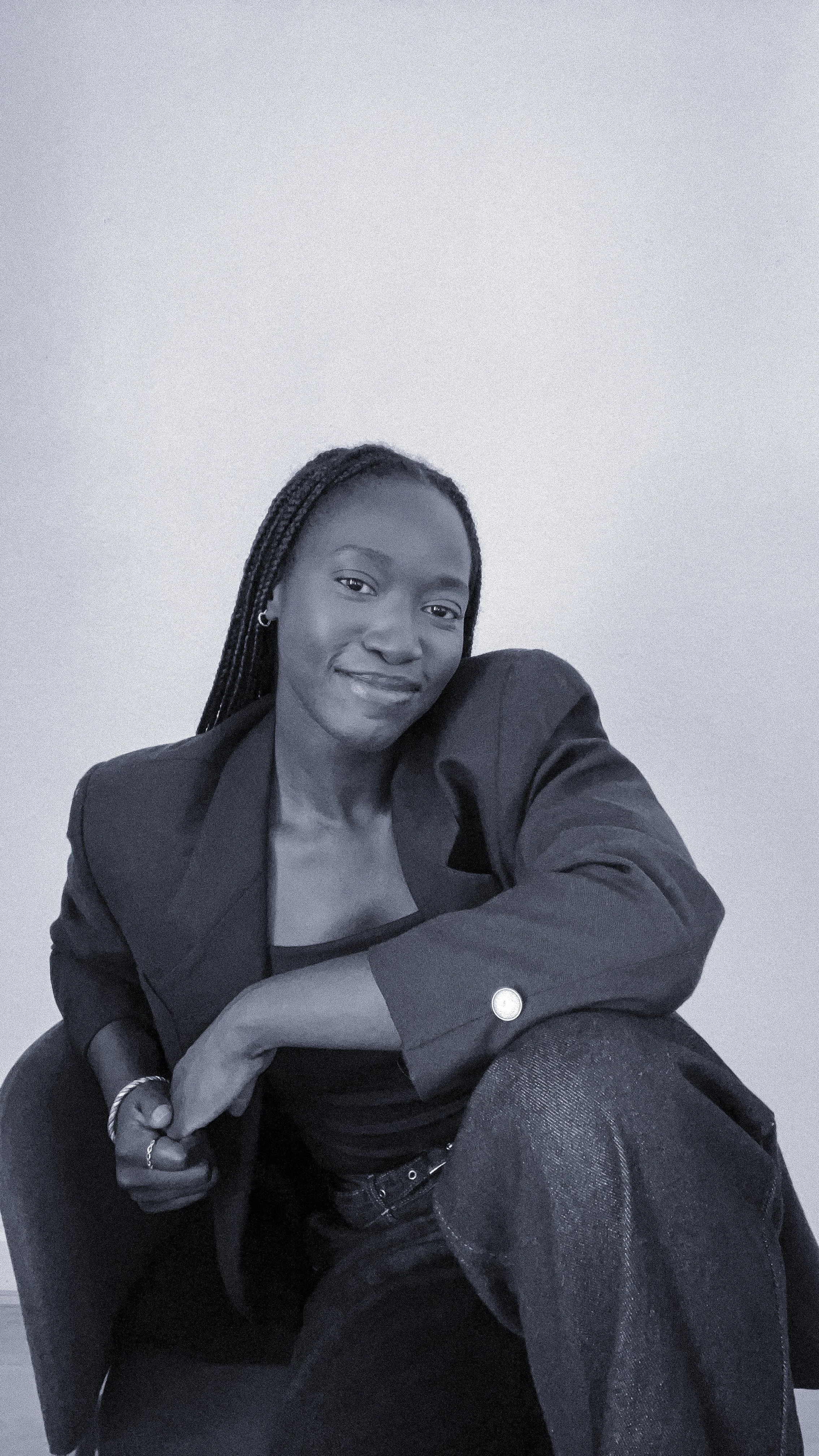 La Fondatrice, Rahma Baradji, portant une veste noire, assise dans un intérieur avec un mur clair en arrière-plan, en noir et blanc.