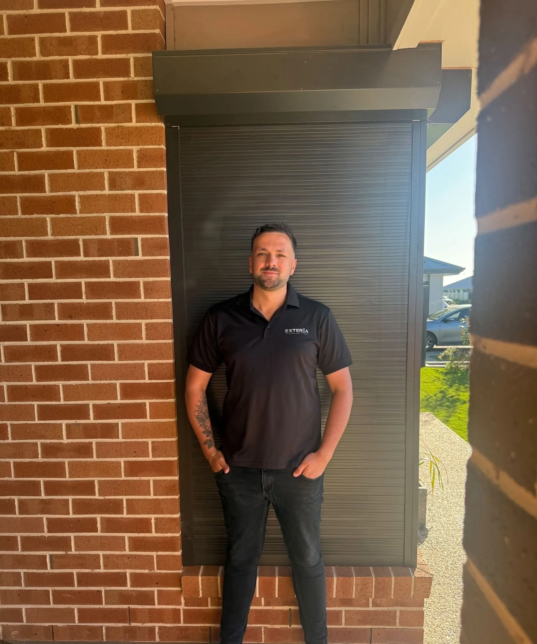 Jayden, founder of Exteria Solutions, standing in front of a roller shutter install