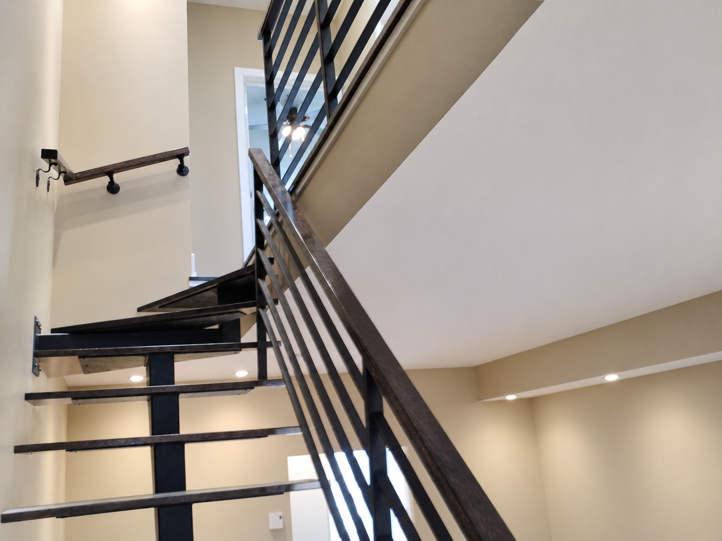 Black metal staircase and railing beside painted walls in a Saint-Laurent condo