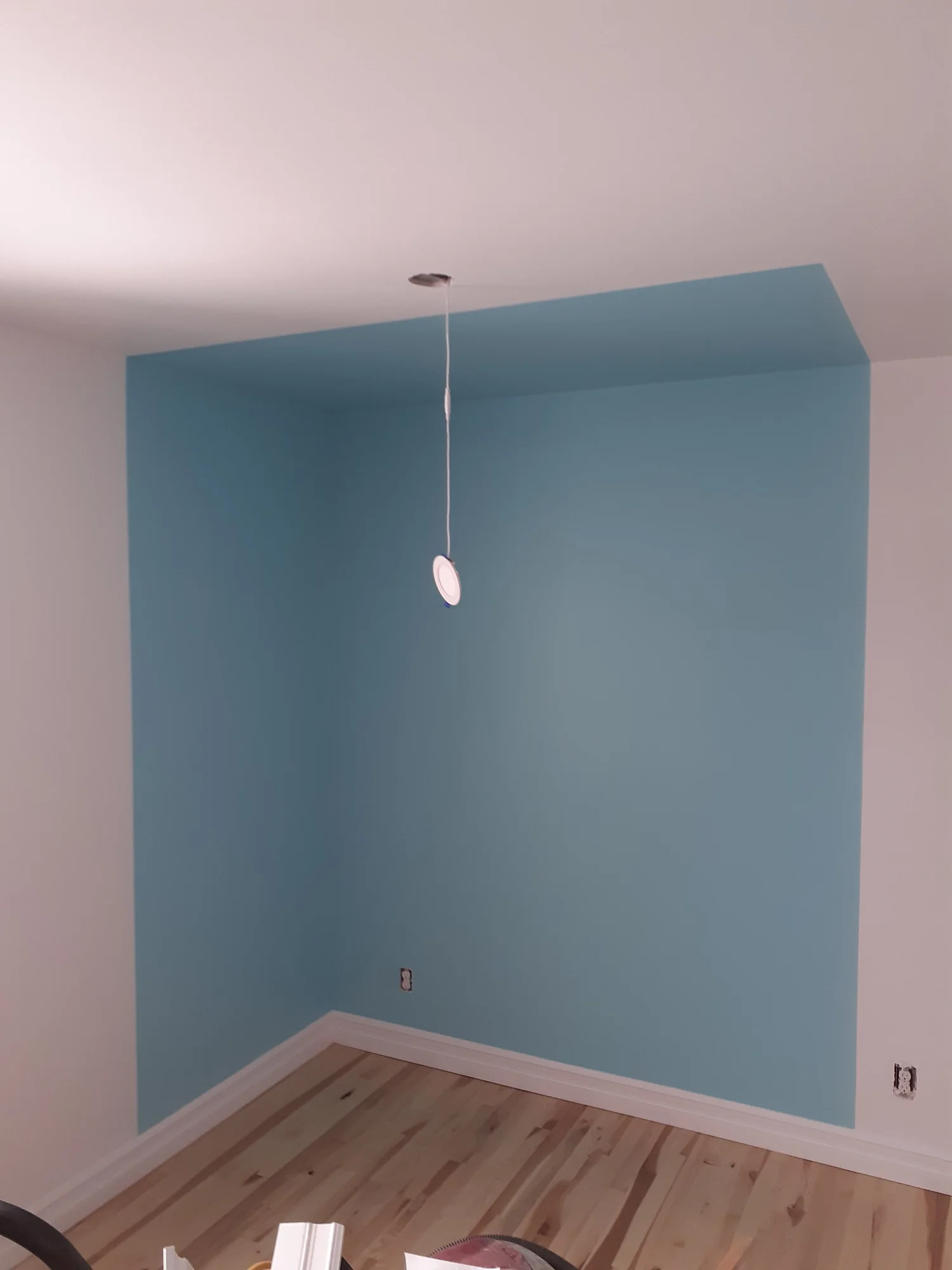 Blue accent wall colour extending across a section of the ceiling