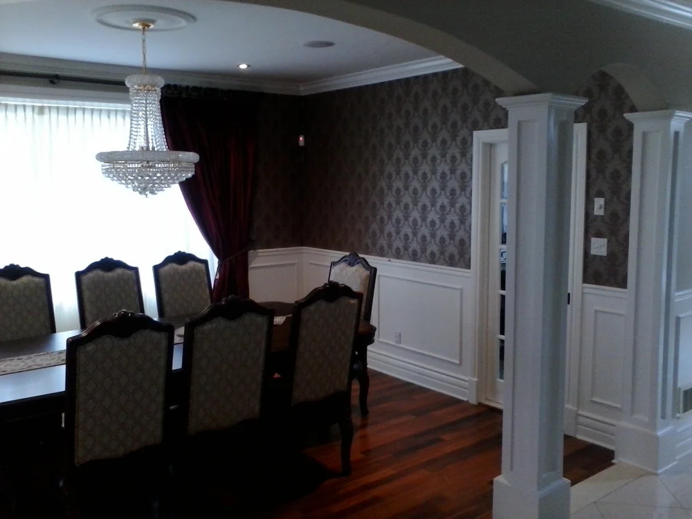 Dining room with a dark patterned wall and white lower wall panels