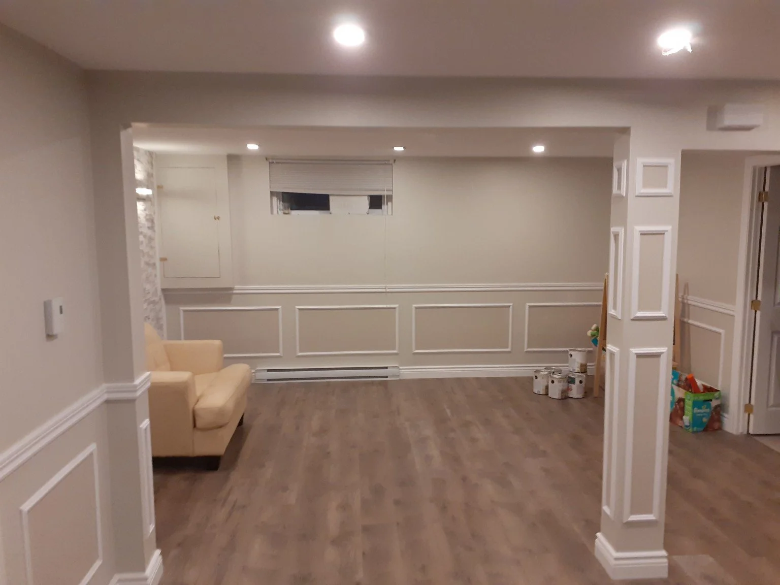 Town of Mount Royal basement with painted walls, white decorative wainscoting and wood flooring