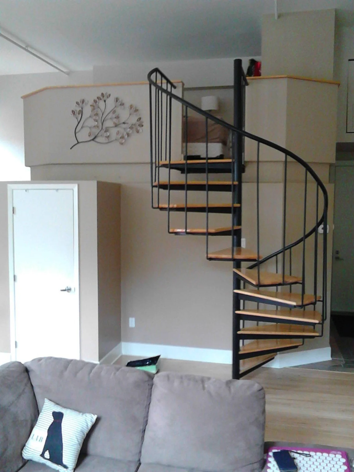Painted loft condo interior with a curved spiral staircase above the living area