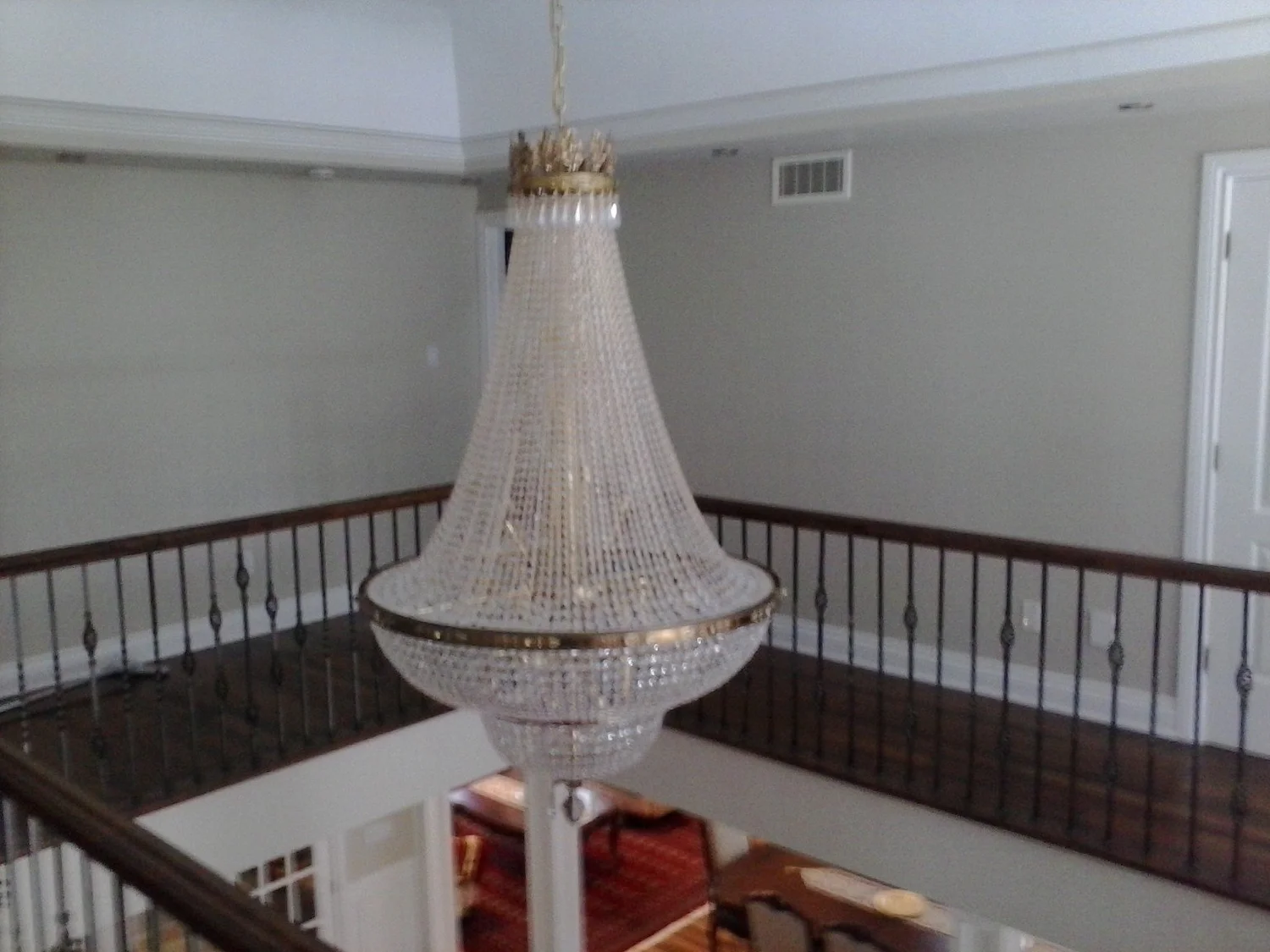 Chandelier suspended in a two-storey stairwell viewed from the upper floor in Bois-Franc