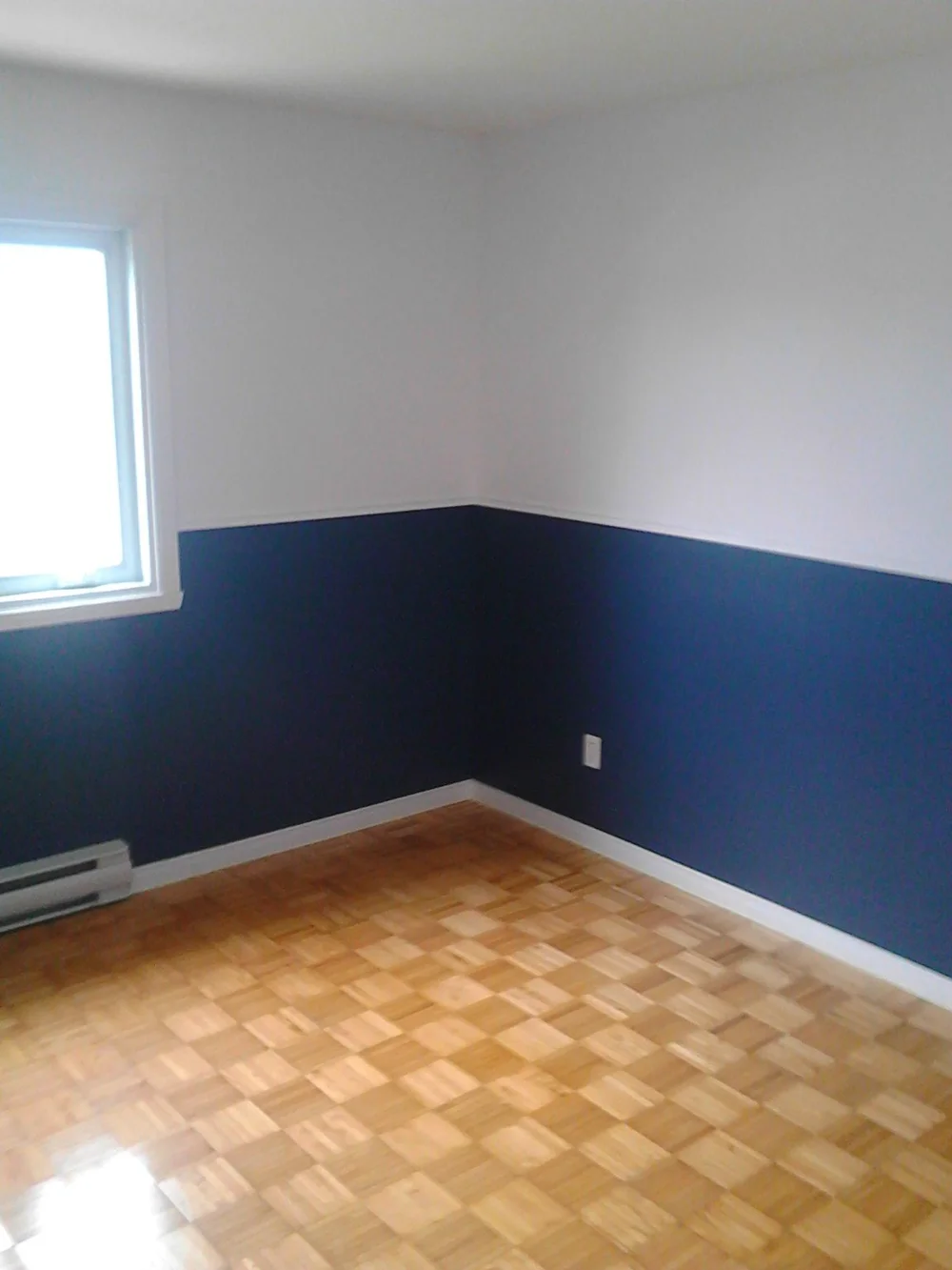 Blue room with white chair rail and wood flooring