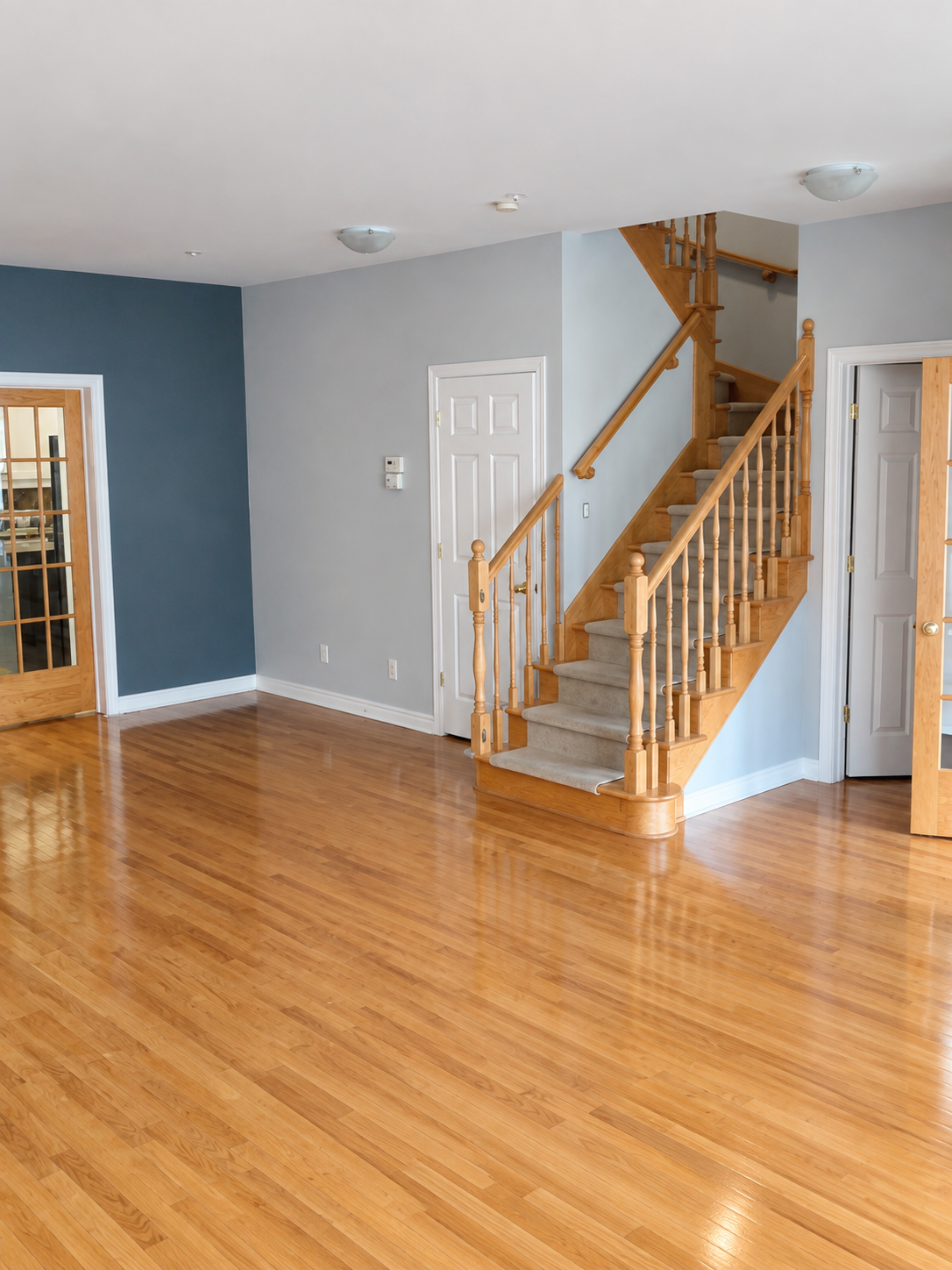 Living room with a dark blue painted accent wall beside a wooden staircase