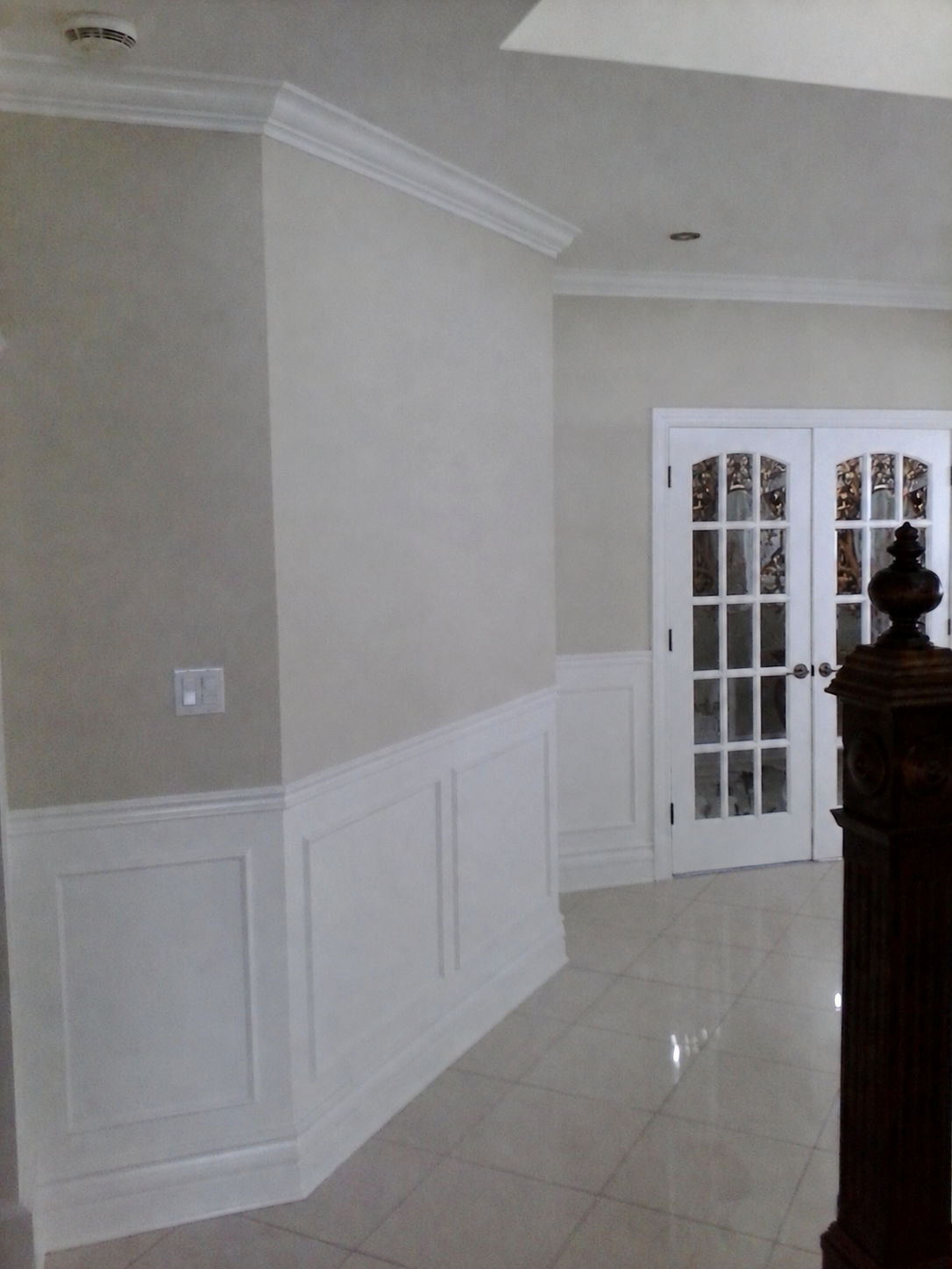 Bois-Franc entry hallway with painted white wainscoting, crown moulding and French doors