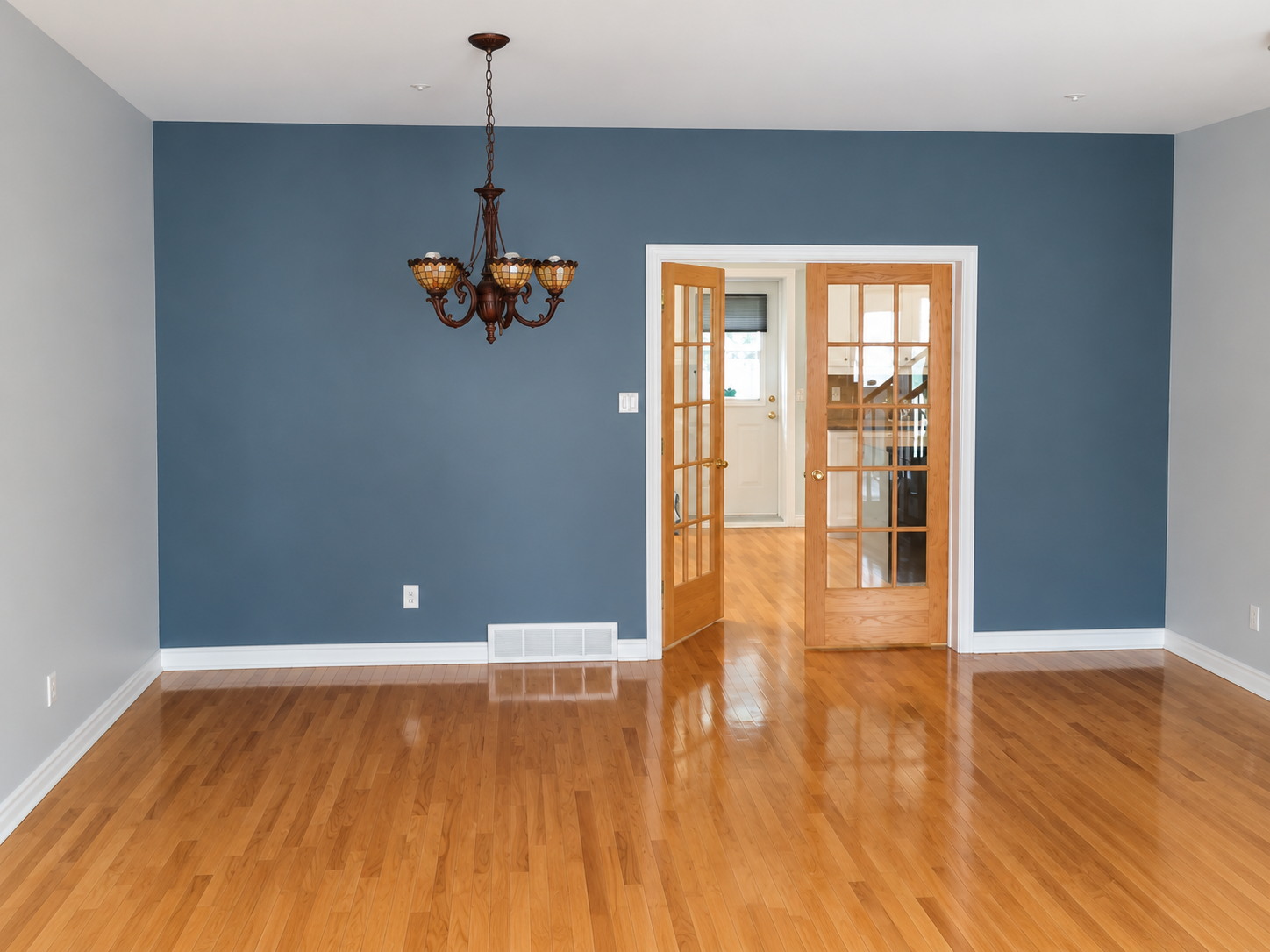 Blue painted accent wall and French doors in a Côte-Saint-Luc living room