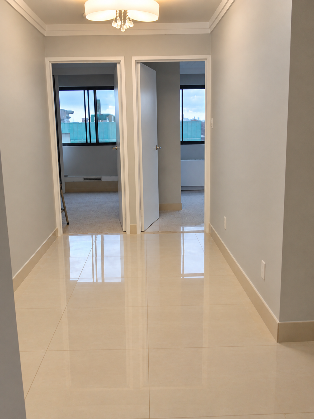 Light condo hallway opening into adjacent rooms