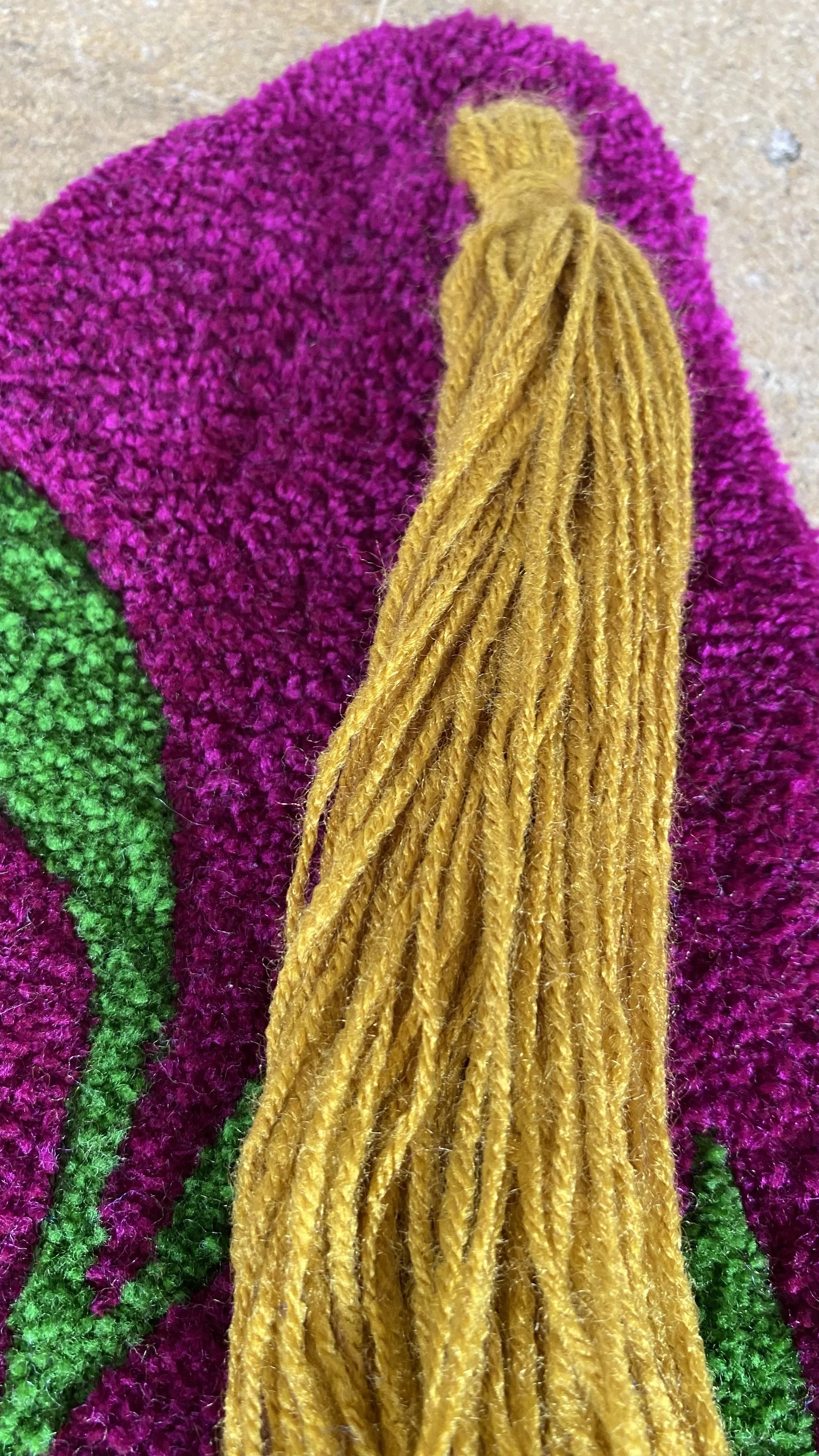Détail de la frange dorée et des finitions artisanales de l'œuvre textile Regard vivant réalisée en tufting manuel.