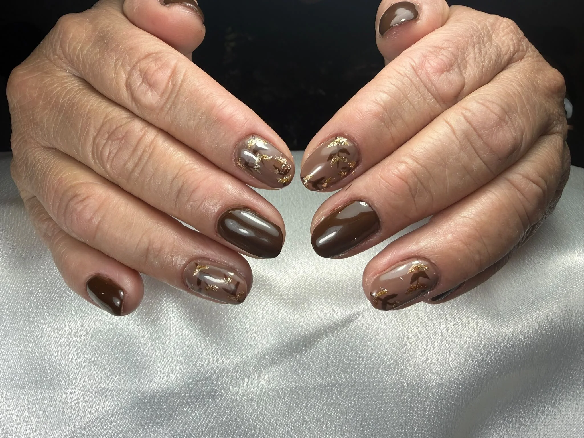 Nahaufnahme von Händen mit bunten, glänzenden Chamäleon-Nagellacken.