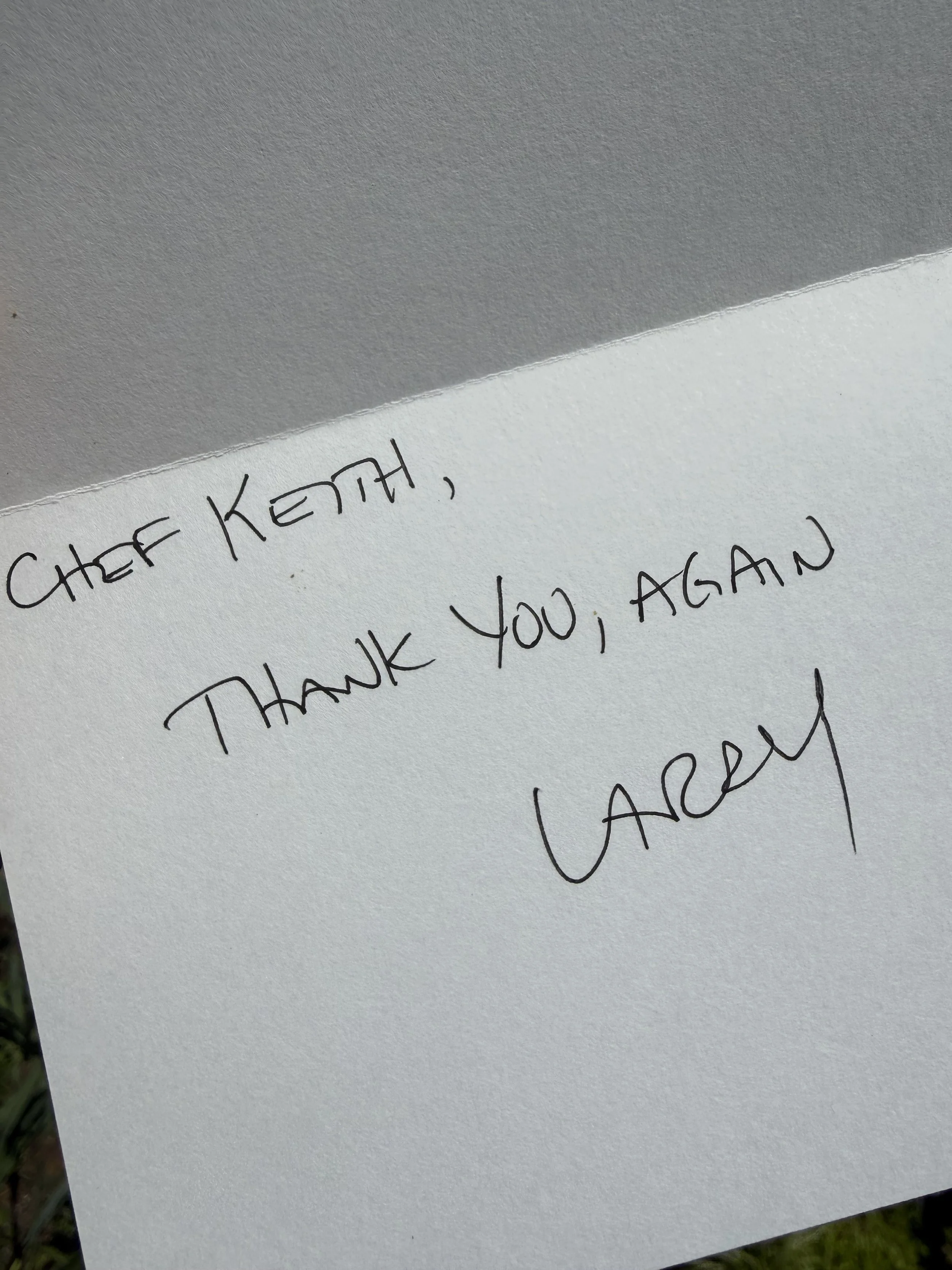 Close-up of a handwritten thank you note addressed to Chef Keith, written on white paper with black ink.