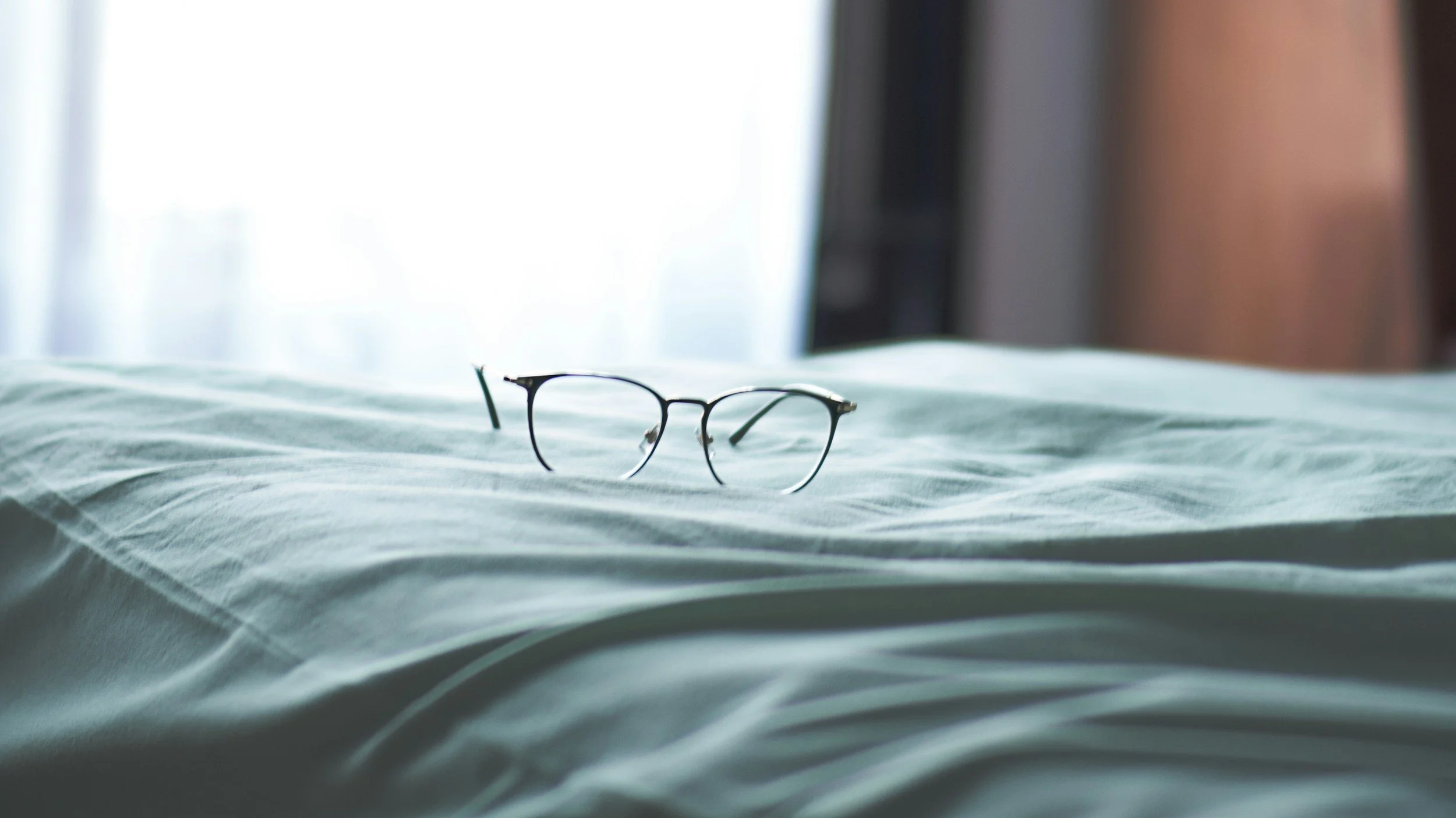reading glasses on a bed